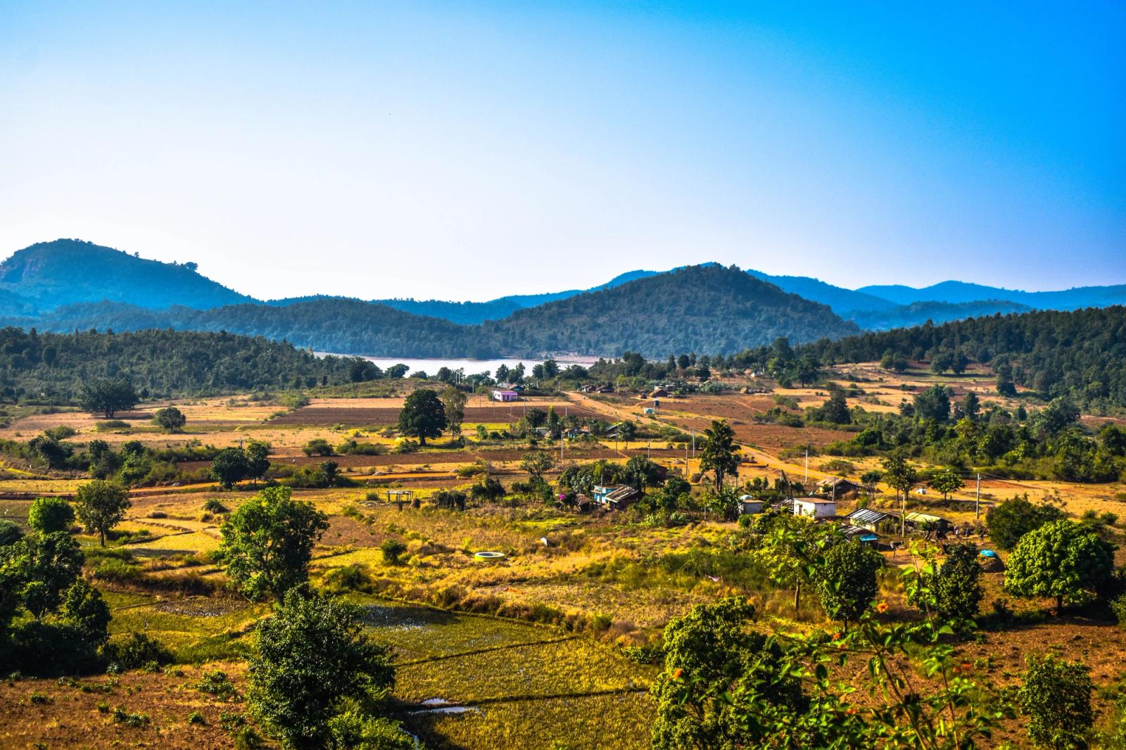 Terraced fields and a scattered village below forested hills