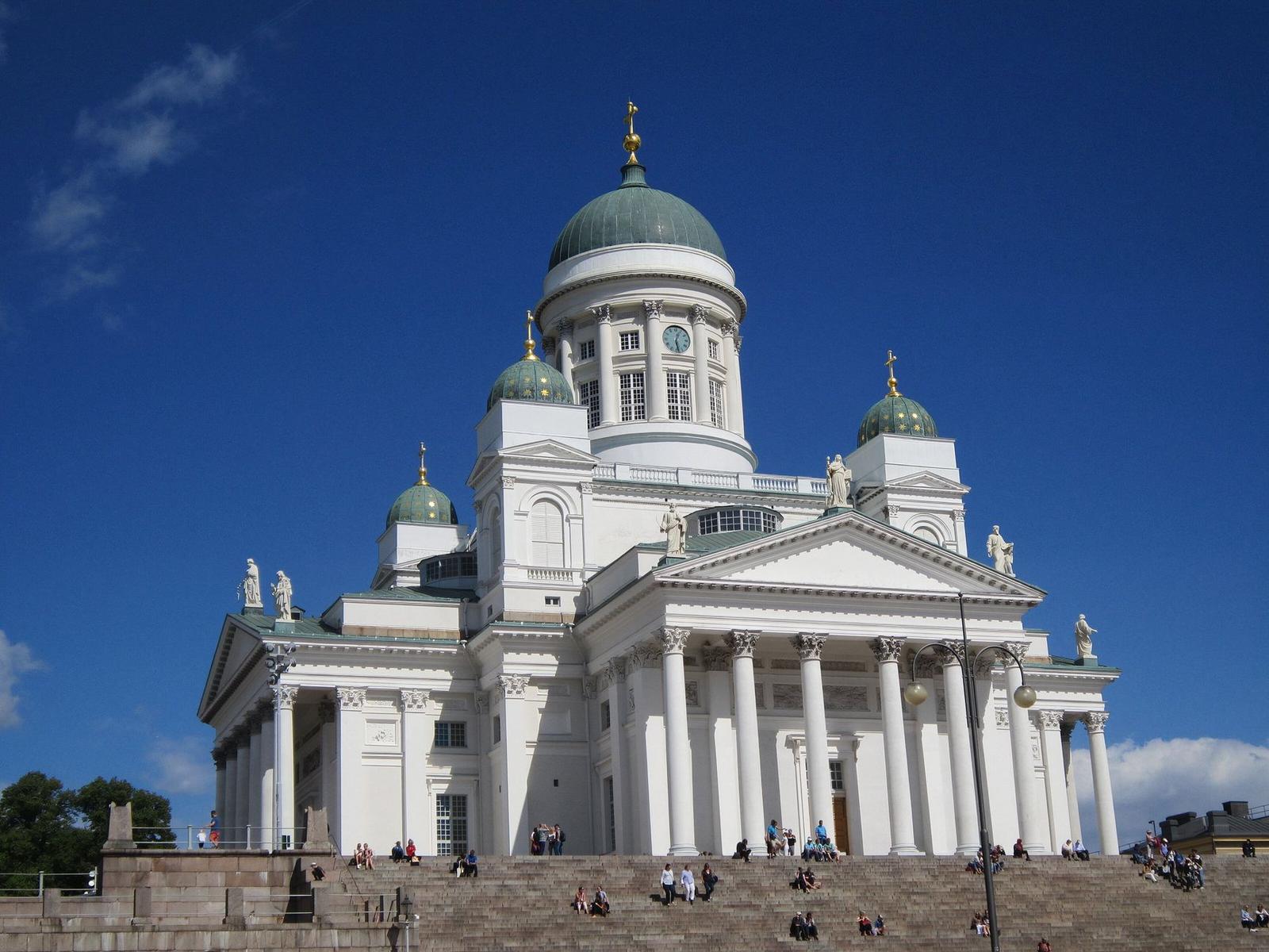 Stunning view of Helsinki Cathedral under a clear blue sky with visitors on the steps