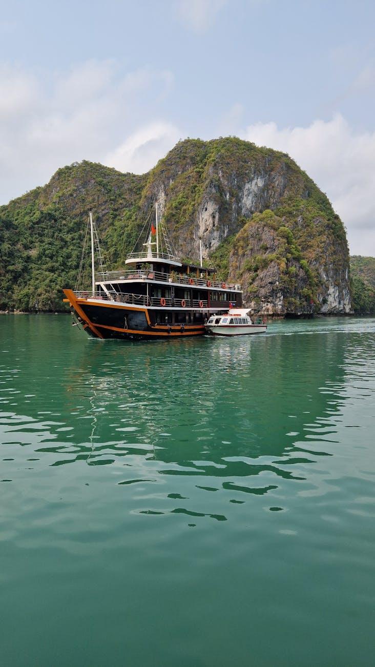 Tourist boat cruising in Halong Bay amid stunning limestone islands and emerald waters