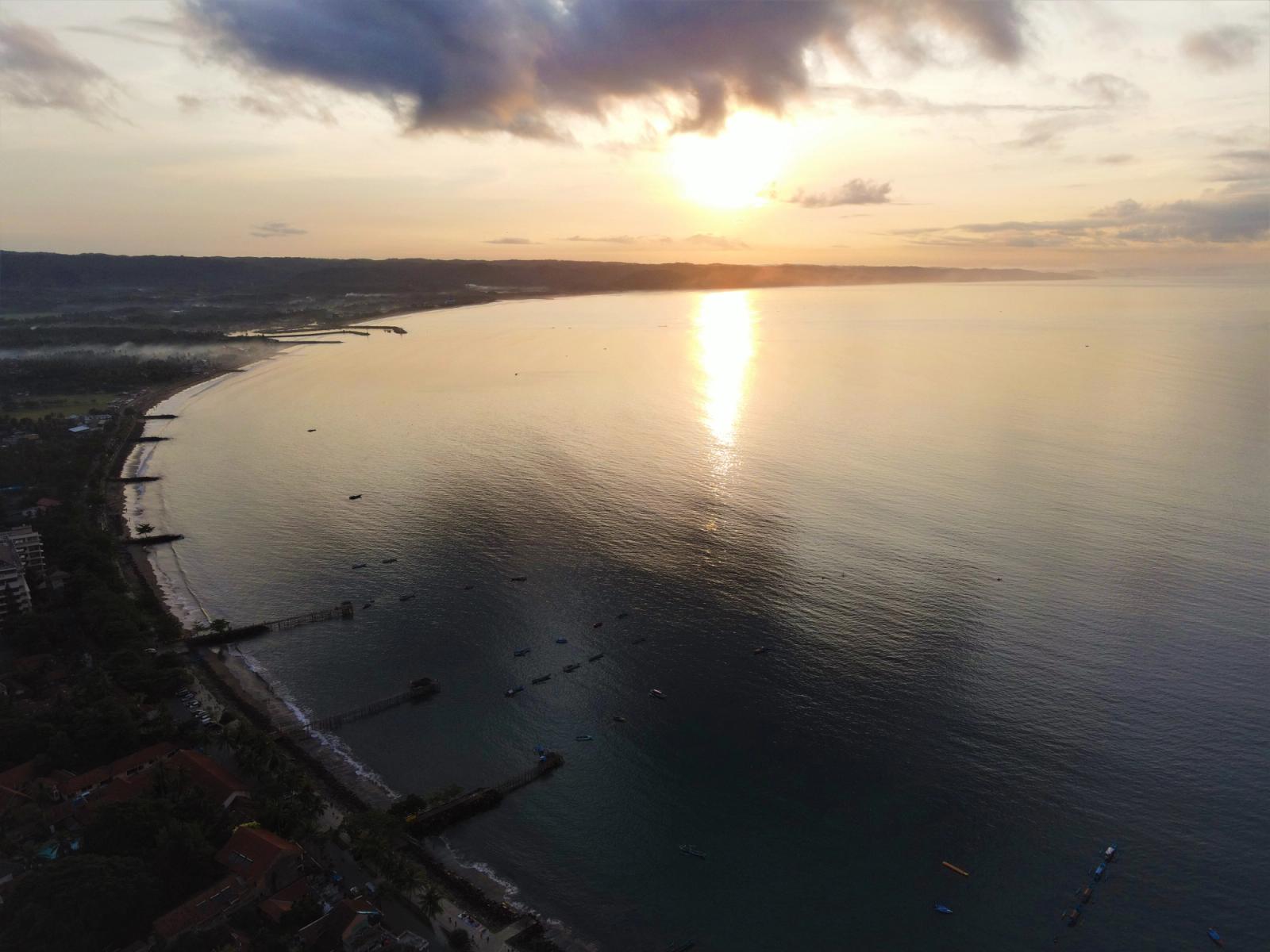 Stunning aerial view of sunrise over Pangandaran, Indonesia coastline, capturing the serene sea and horizon