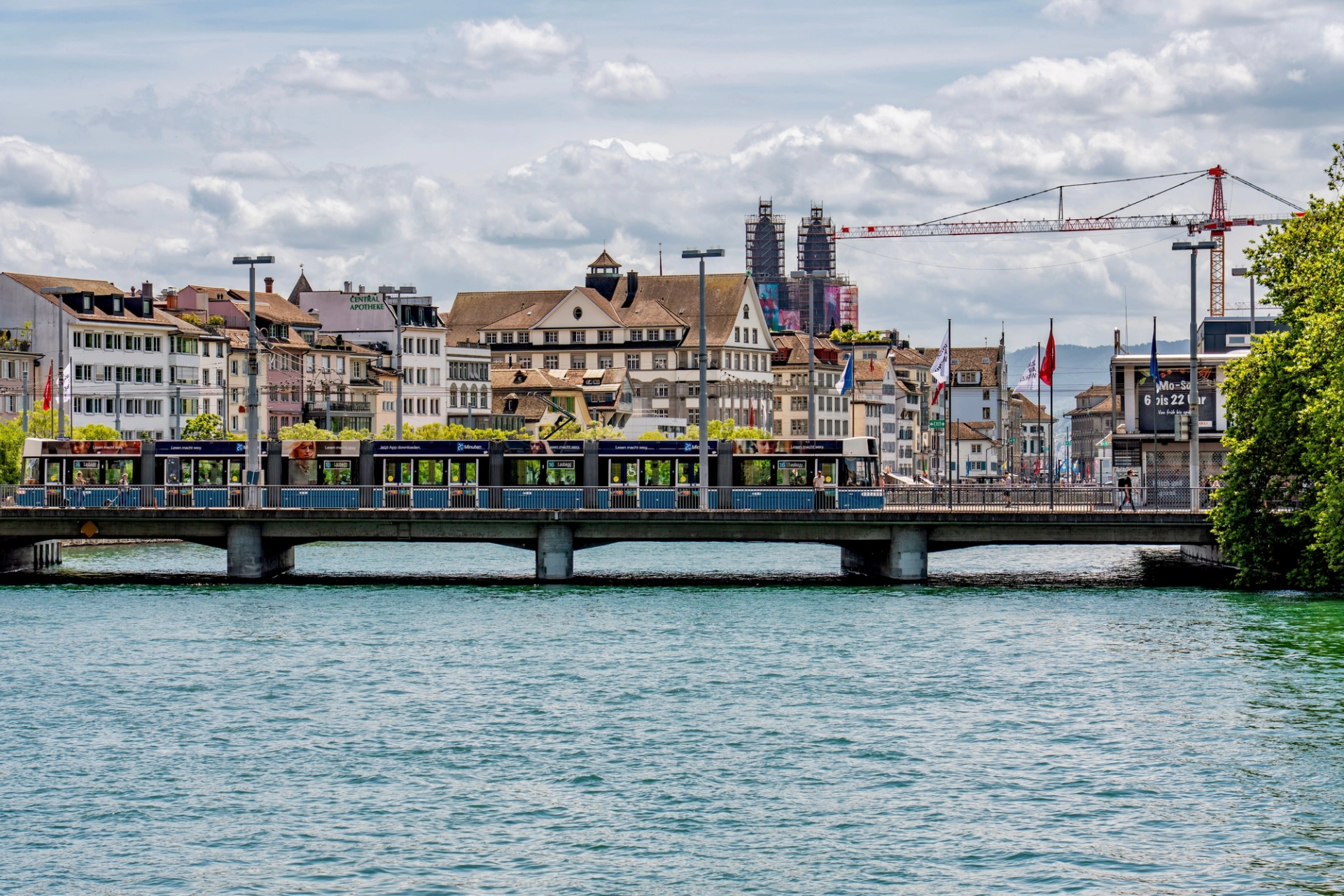 Beautiful cityscape of Zurich with a bridge and tram over the Limmat River on a sunny day