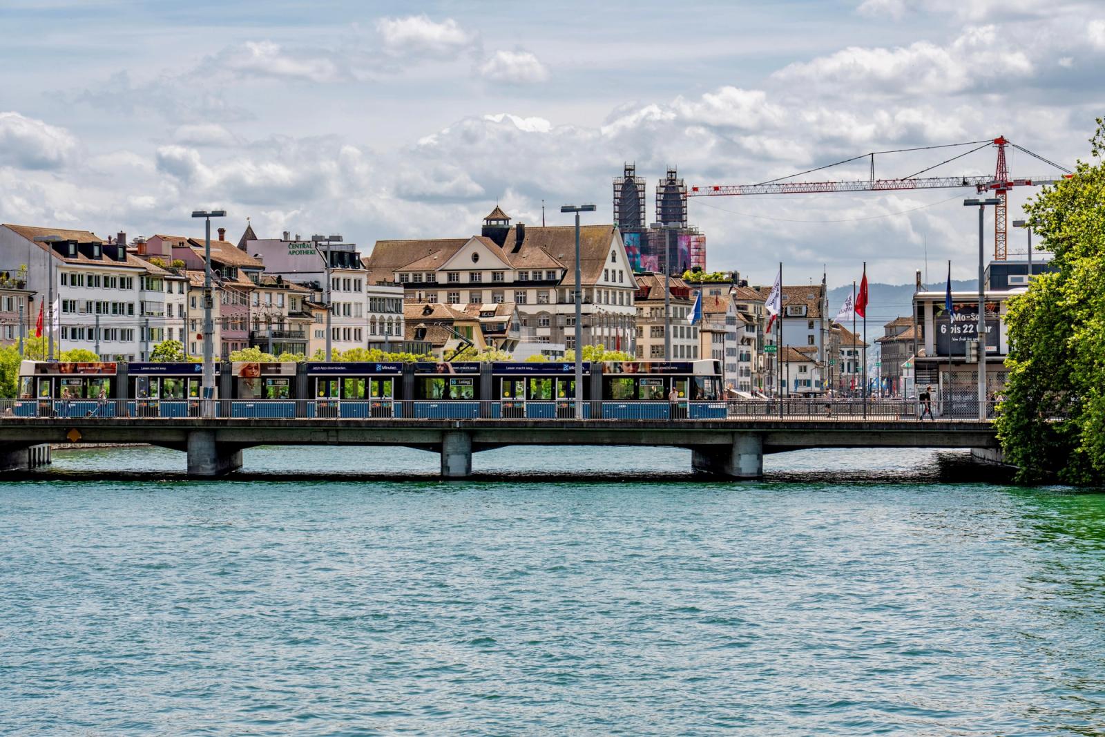 Beautiful cityscape of Zurich with a bridge and tram over the Limmat River on a sunny day