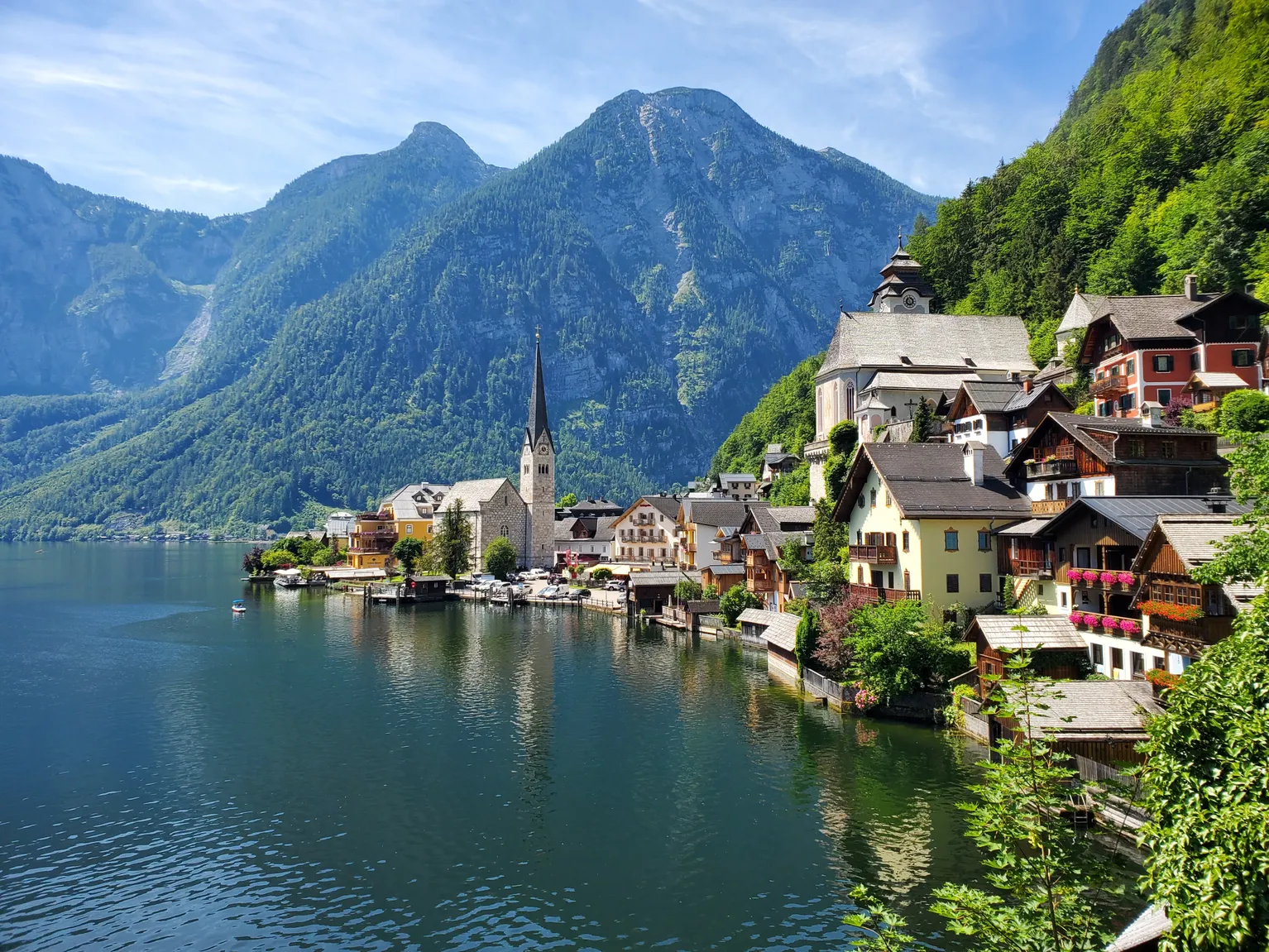 A lakeside village with a church spire framed by green mountains