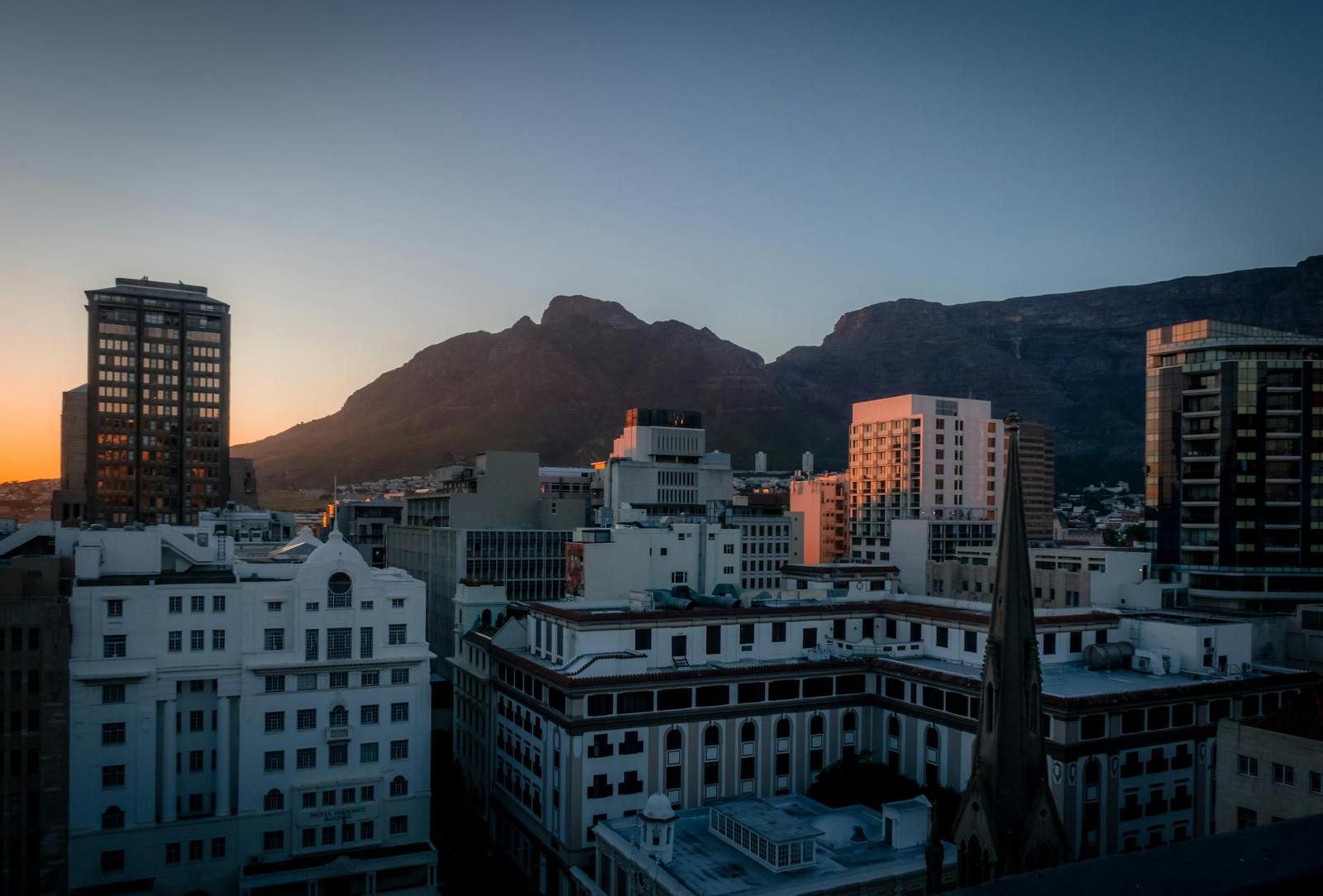 Downtown skyline with mountain range glowing at sunset