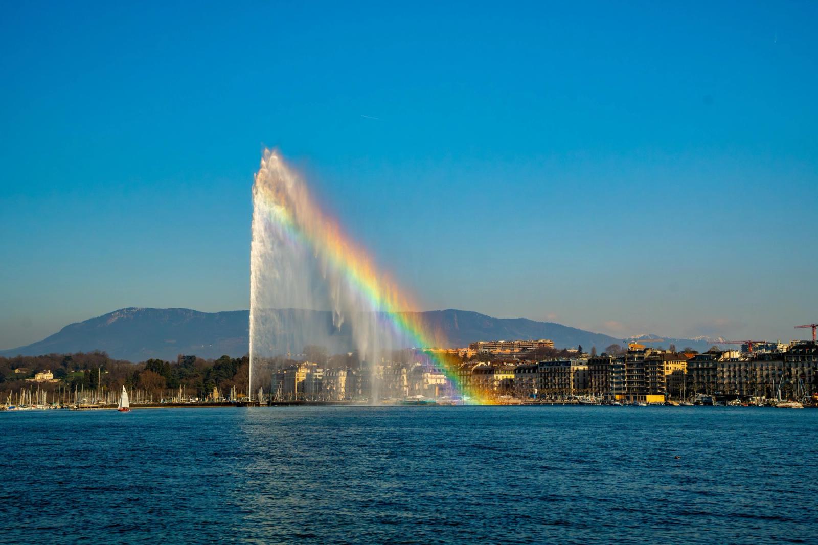 Stunning view of Jet d'Eau fountain with a rainbow over Lake Geneva in Switzerland