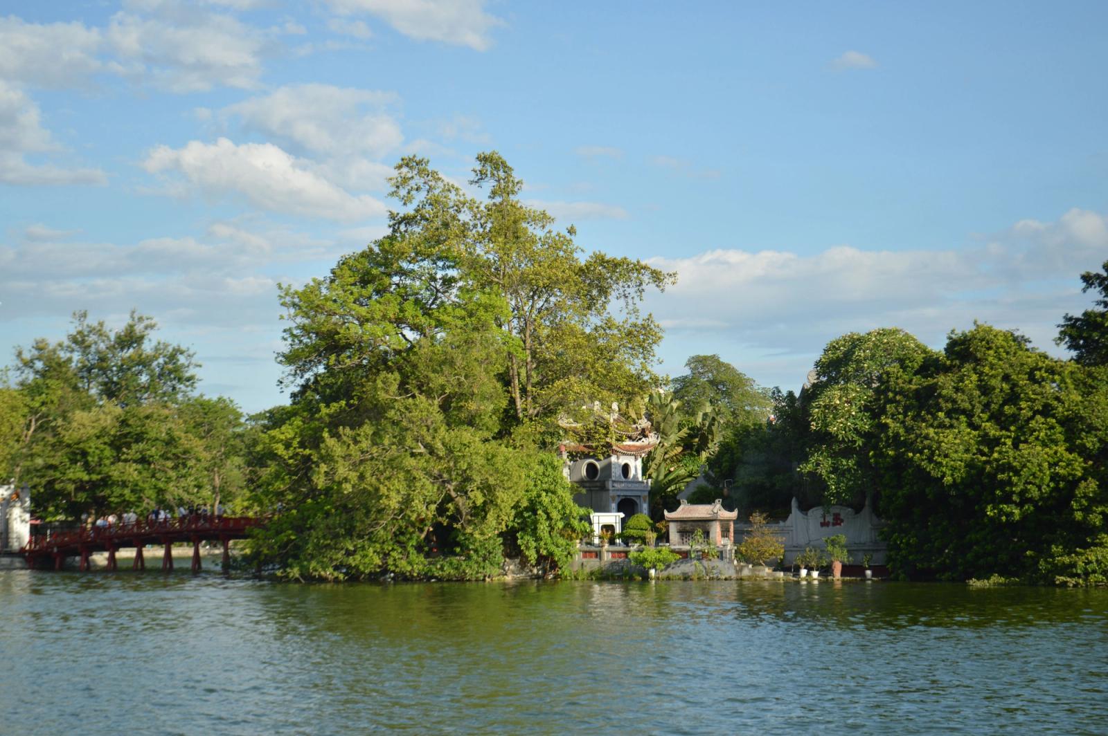 Serene view of Ngoc Son Temple and red bridge on Hoan Kiem Lake, Hanoi, under a clear blue sky