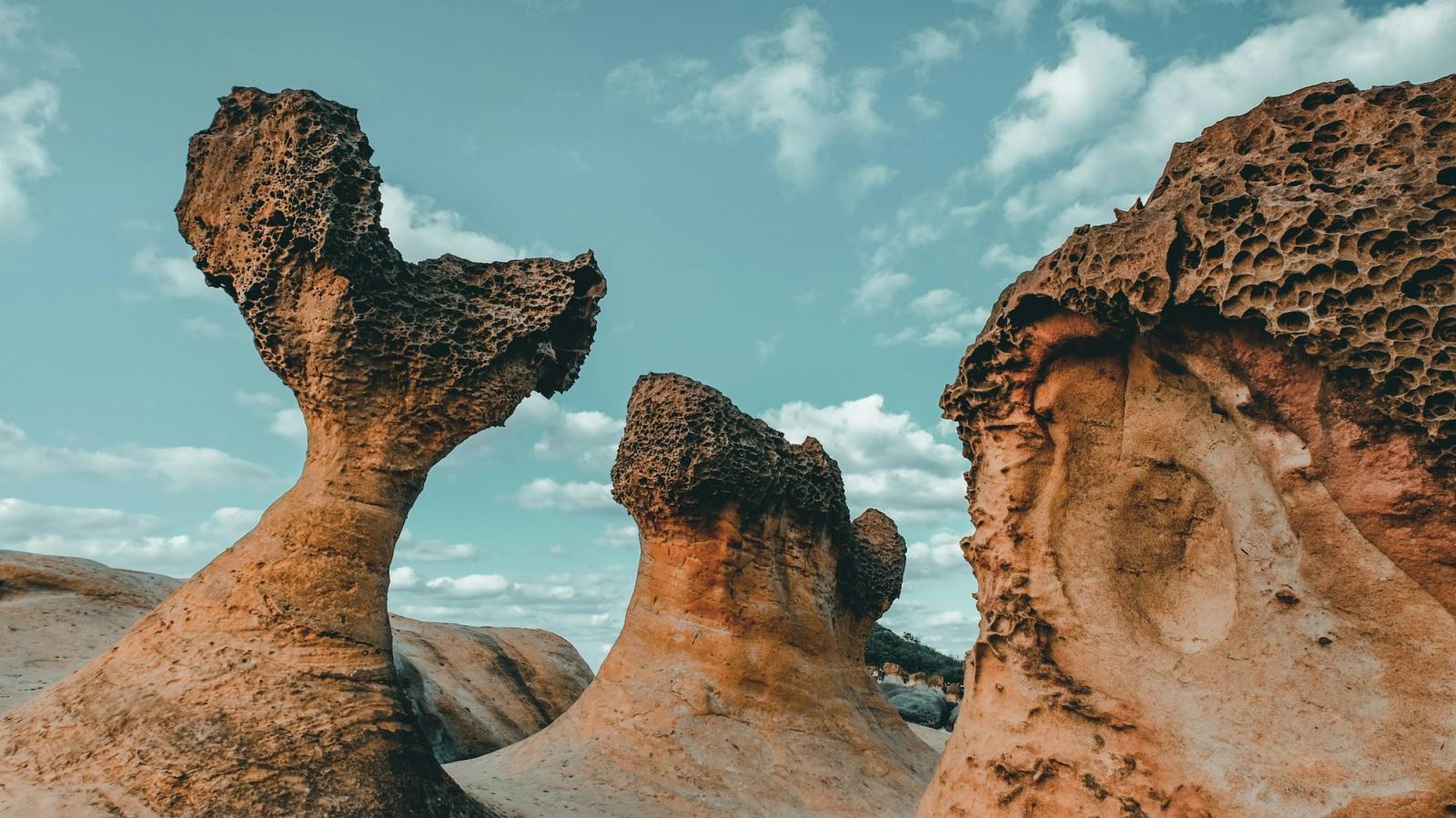 Wind-eroded mushroom-shaped rock formations rising against a blue sky