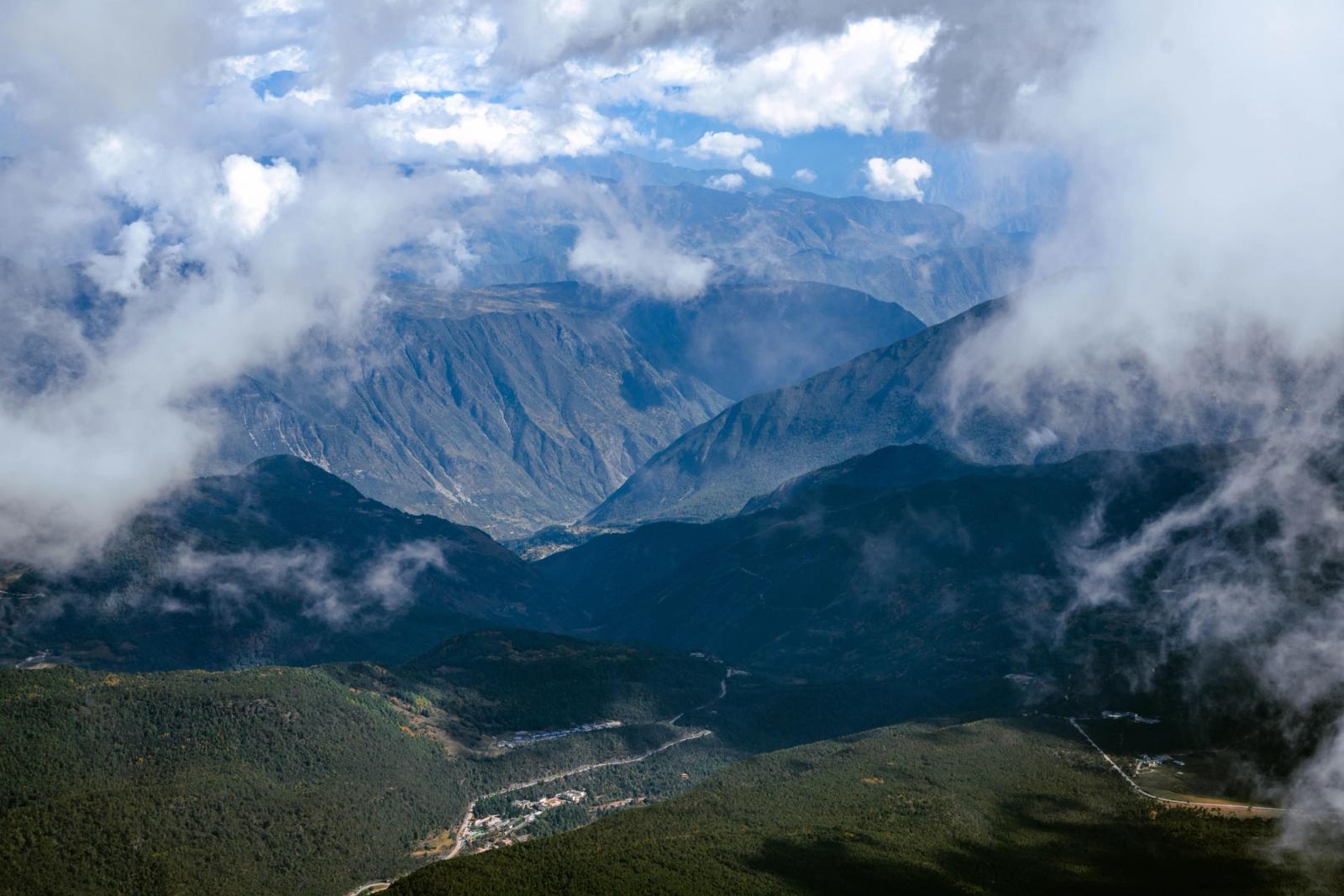 A stunning aerial view of mountains shrouded in clouds, showcasing rugged terrain