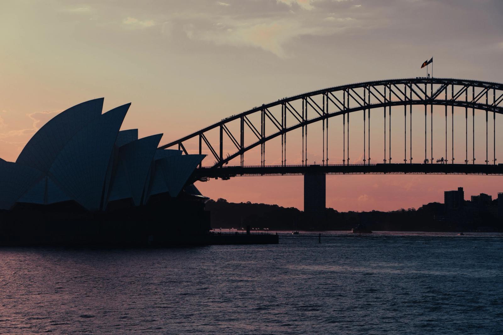 Captured at dusk, the Sydney Opera House and Harbour Bridge create a majestic skyline over Sydney Harbour