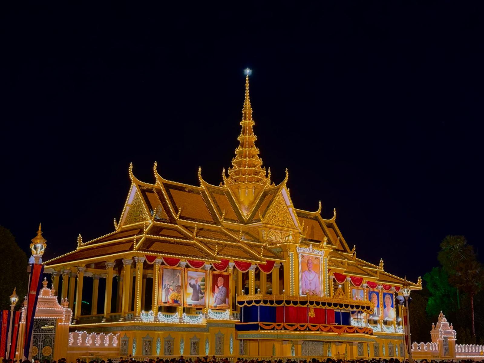 A palace hall illuminated in gold and red against a night sky