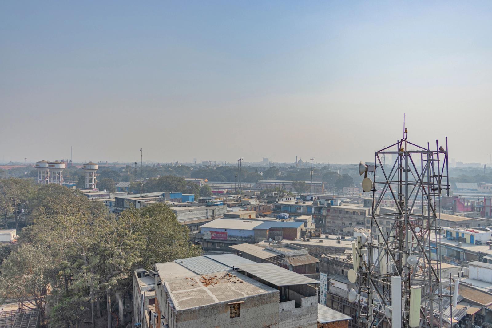 Aerial view of urban buildings and trees with a telecom tower in New Delhi, India