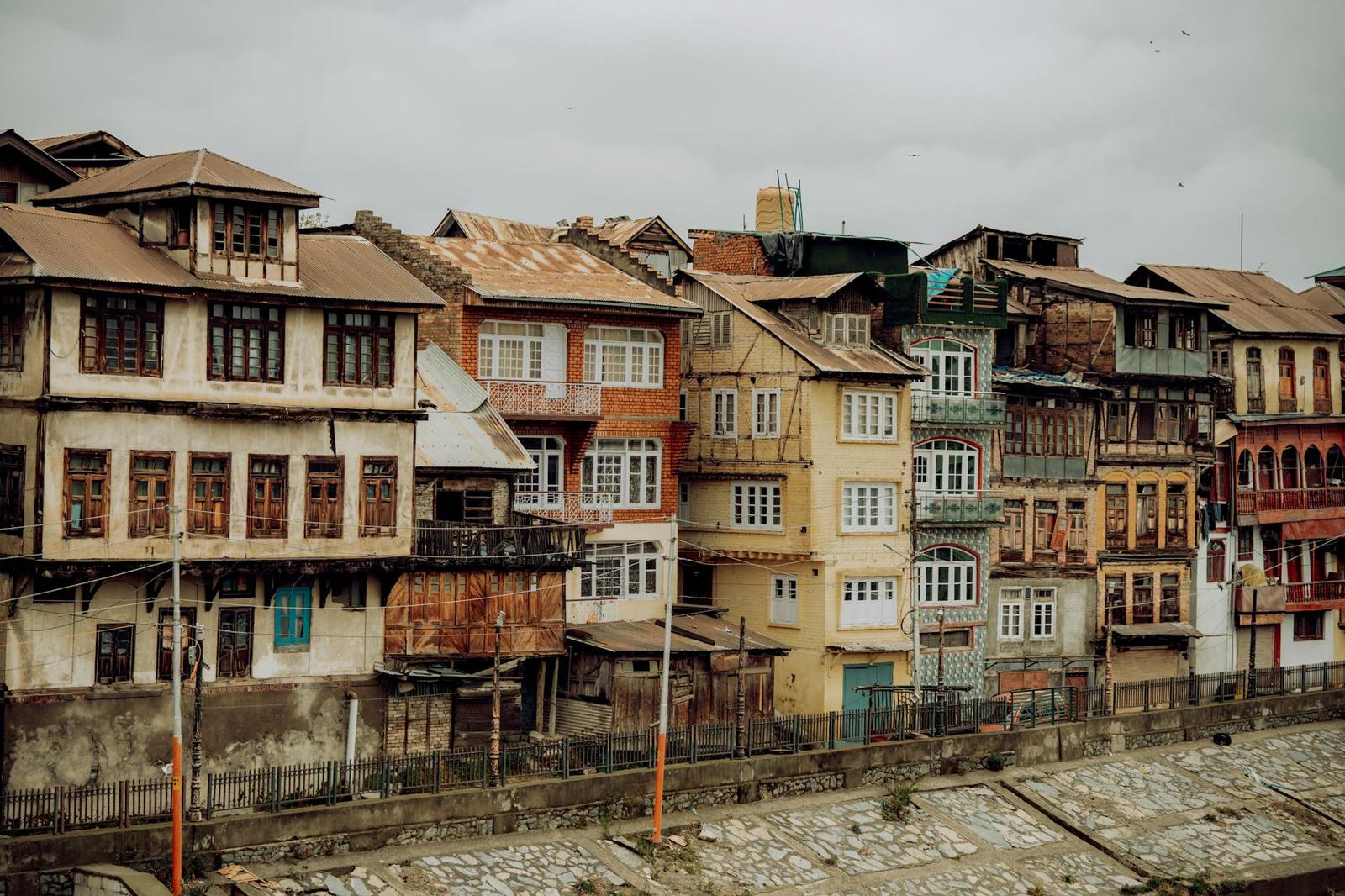 A row of weathered wooden houses along a riverside street