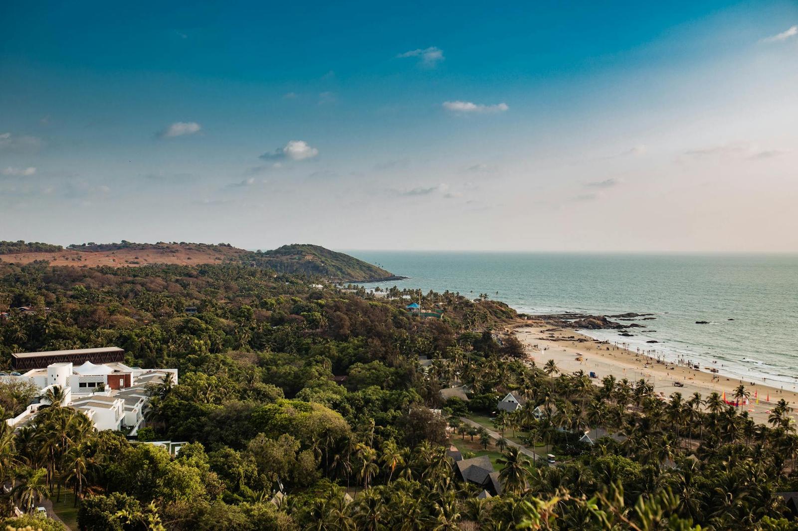 A hillside overlooking a curved beach and turquoise sea