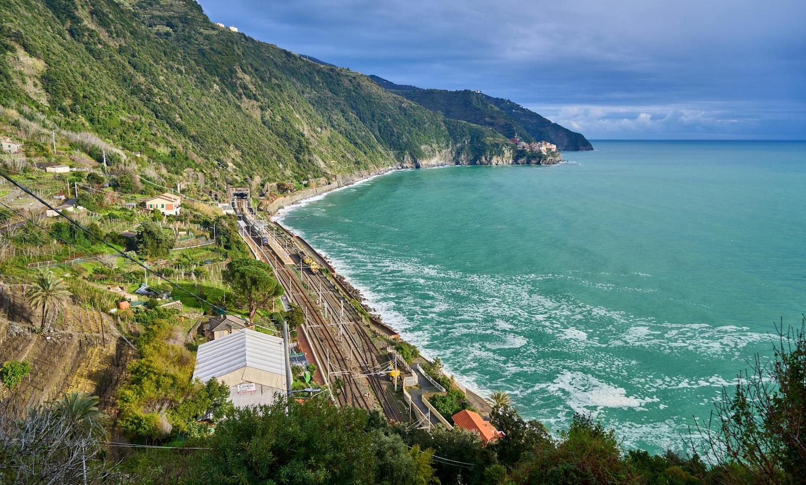 A coastal railway curving along cliffs above a turquoise sea