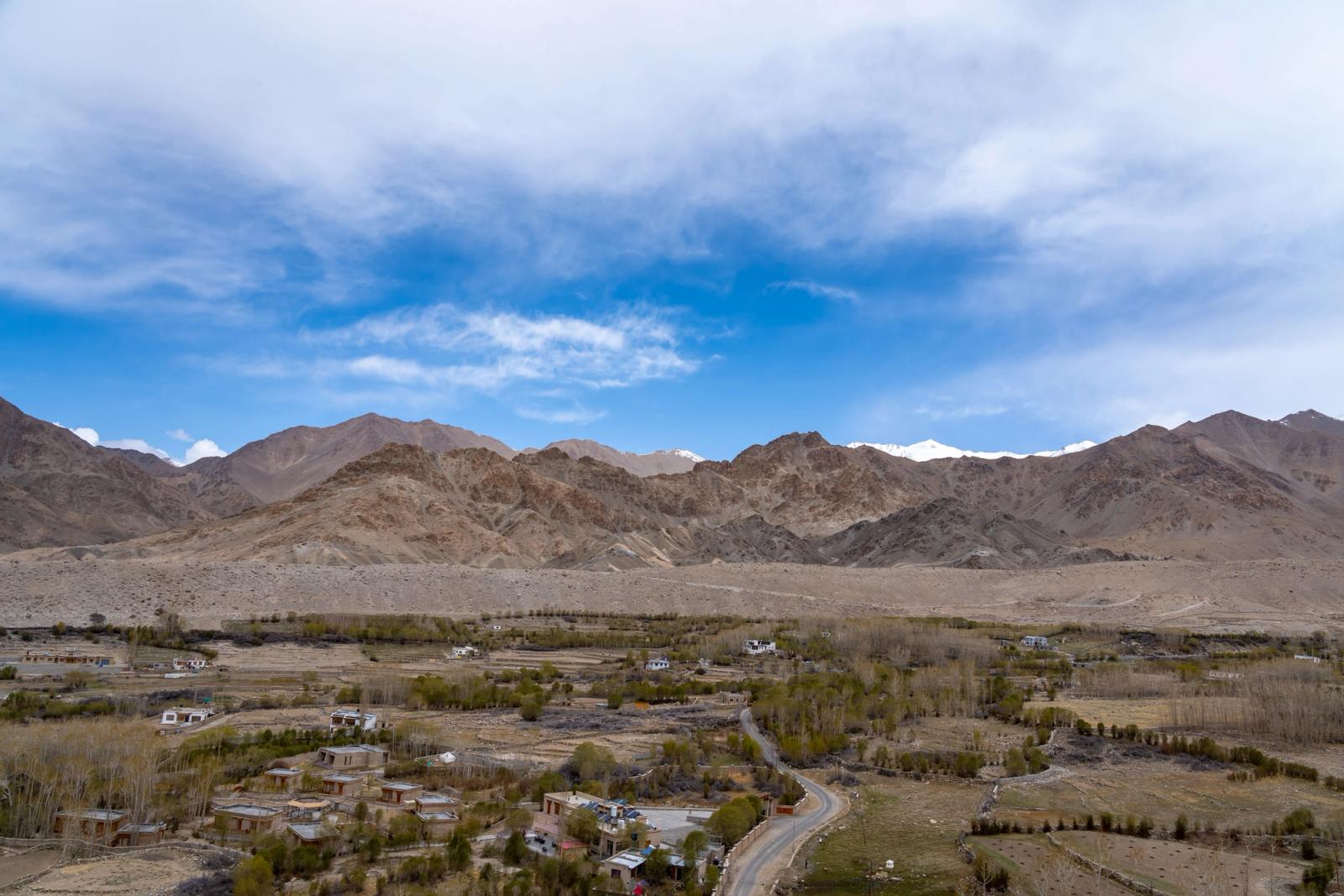 Breathtaking landscape of Leh with majestic mountains and serene valley under a vibrant sky