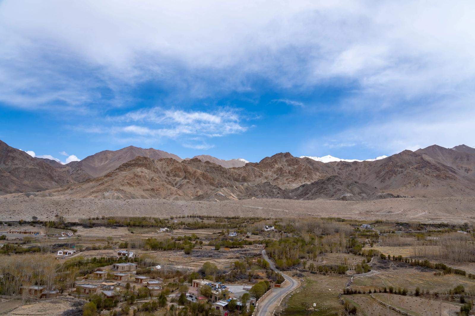 Breathtaking landscape of Leh with majestic mountains and serene valley under a vibrant sky