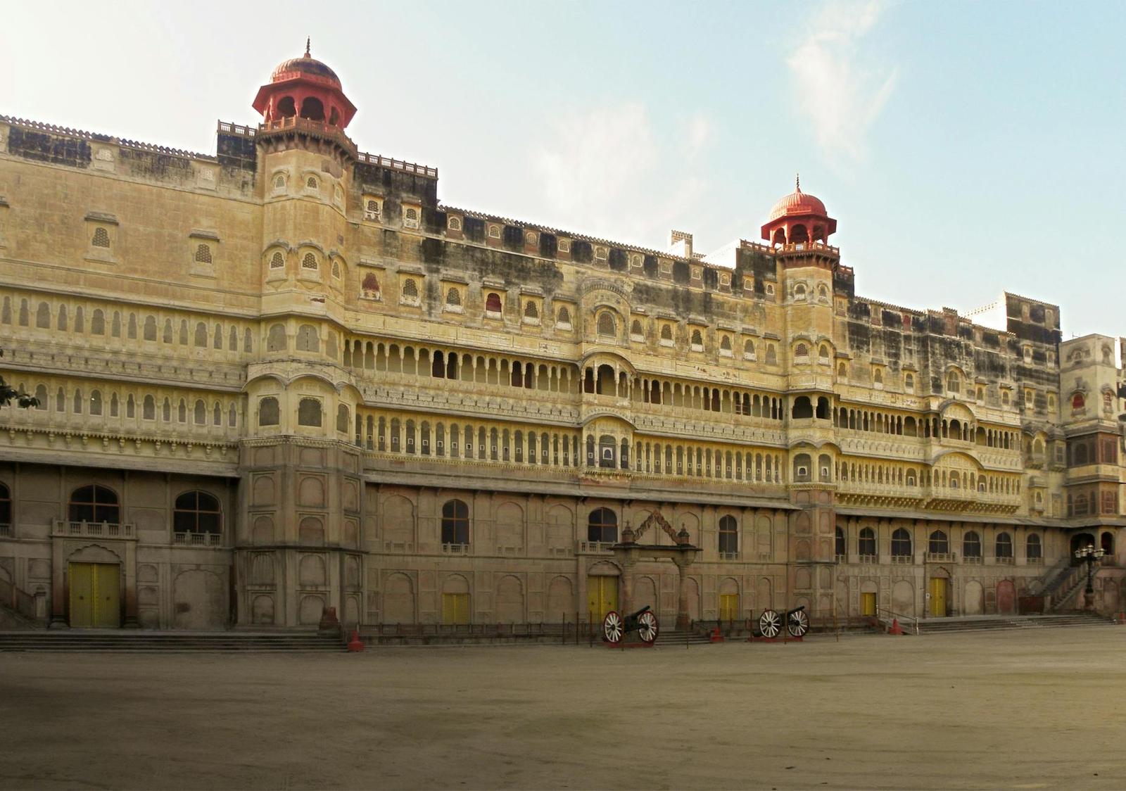 A sandstone palace facade with domed pavilions along its rooftop