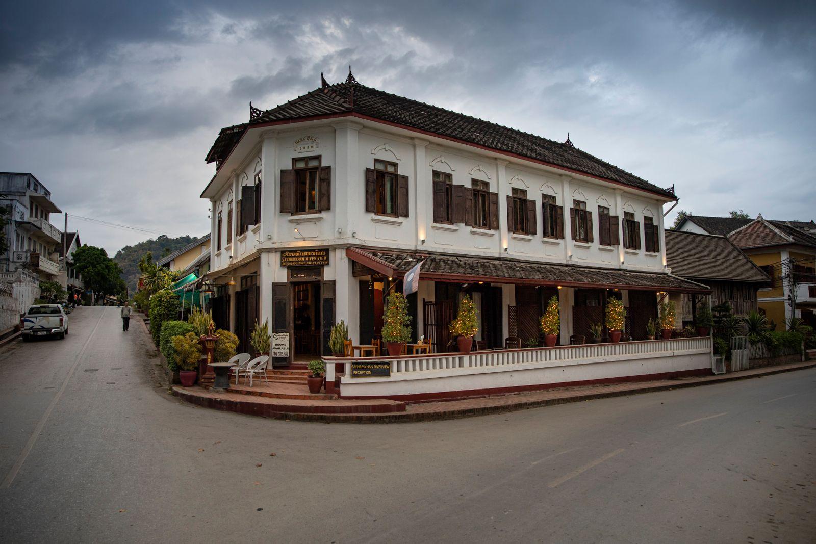 A colonial corner building on a Luang Prabang street at dusk