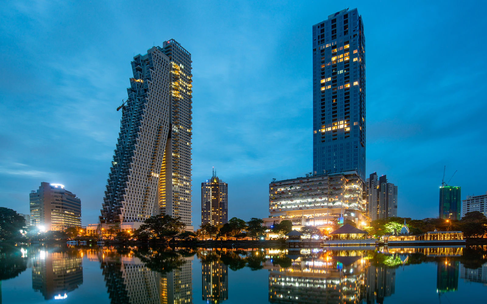 City skyline of high-rise towers reflected in still water at dusk