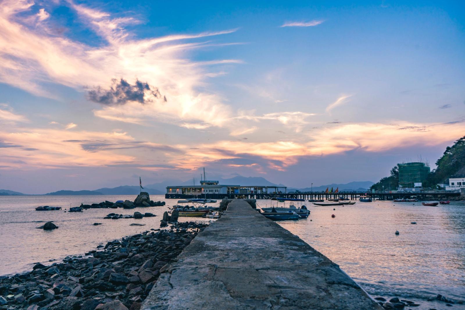 Tranquil sunset view of Sai Kung Pier in Hong Kong with boats and colorful sky