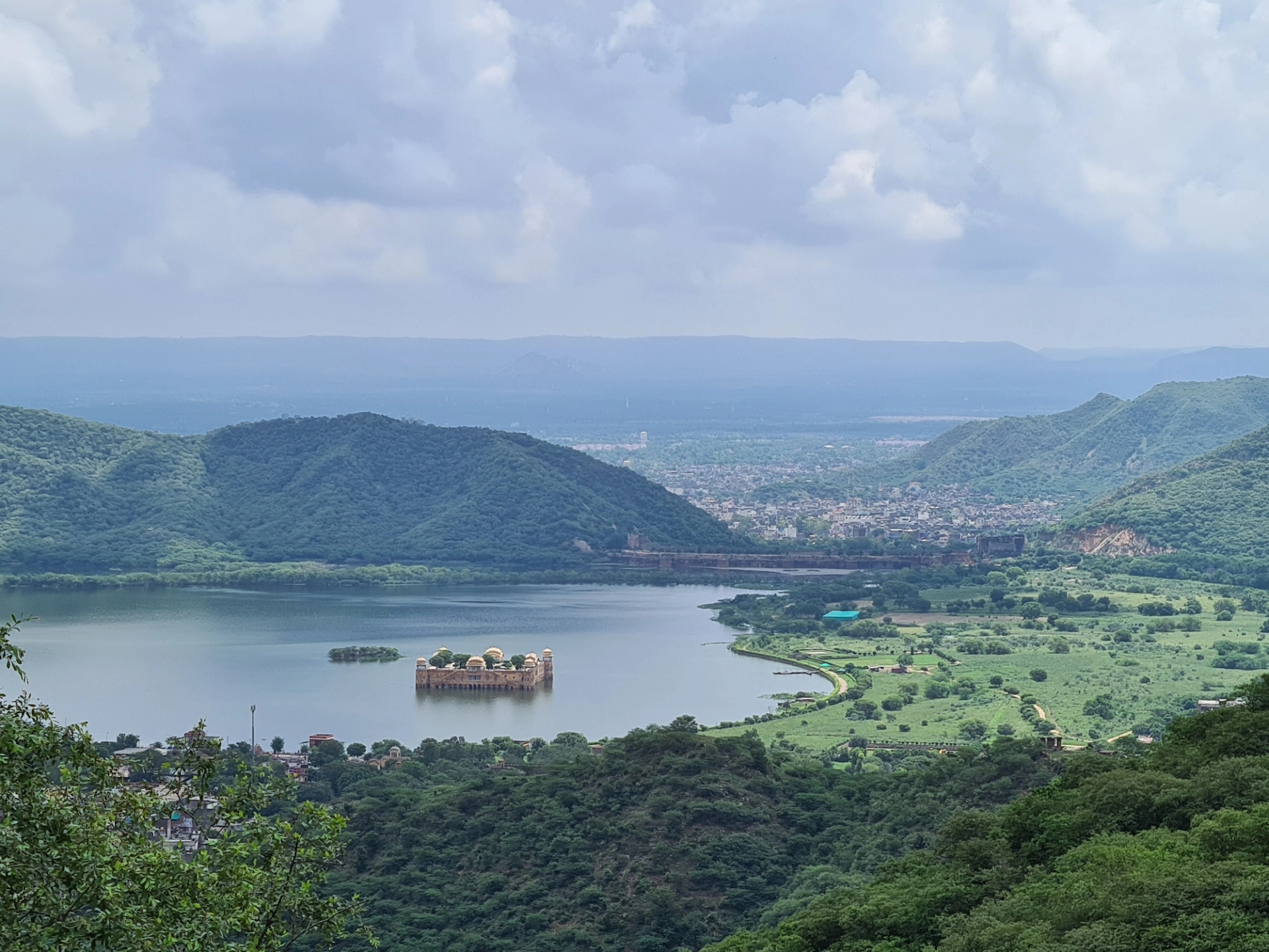 Stunning aerial view of Jal Mahal amidst Man Sagar Lake, Jaipur, surrounded by lush hills