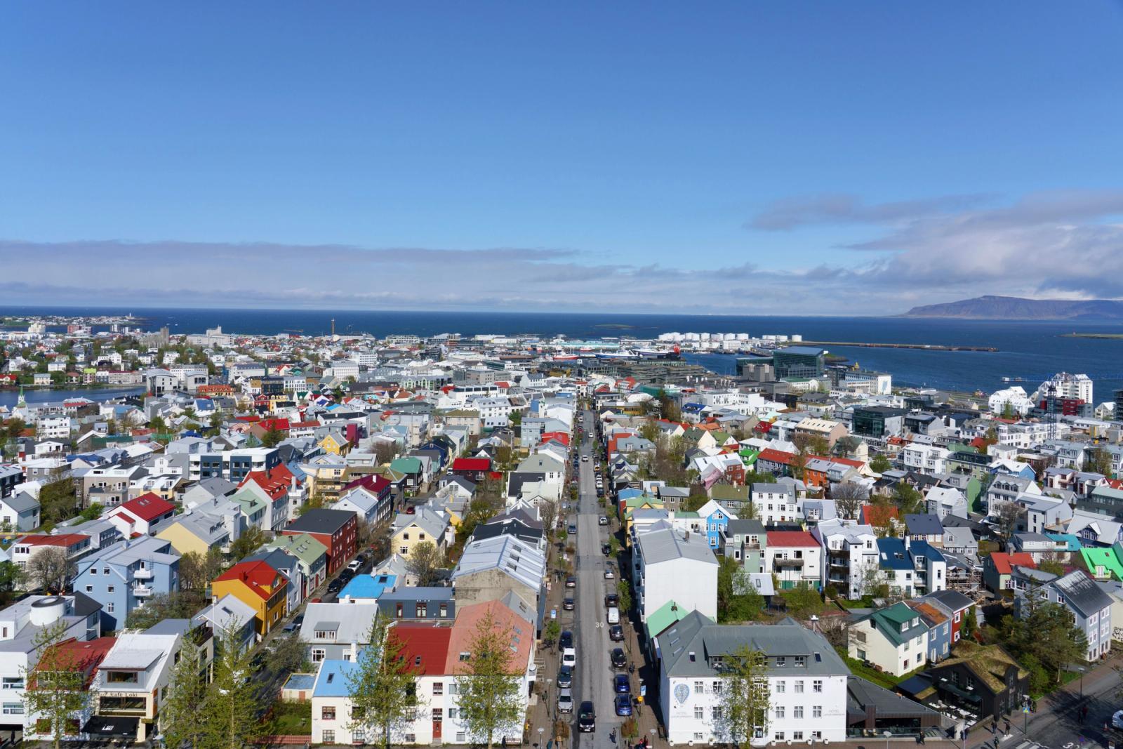 Vibrant aerial view of Reykjavik, Iceland, showcasing colorful rooftops and ocean backdrop under a clear sky