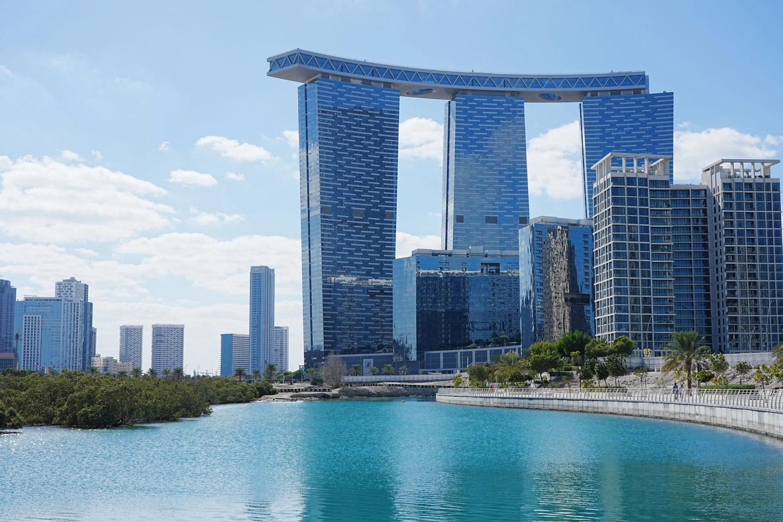 Stunning view of modern skyscrapers by the waterfront in Abu Dhabi, UAE under a clear blue sky