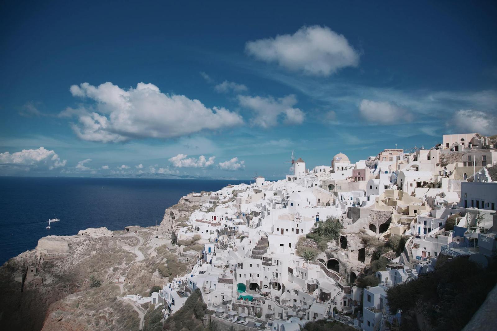 A whitewashed hillside town overlooking a deep blue sea