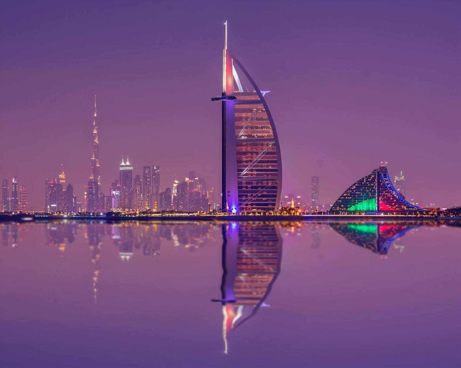 Captivating night scene showcasing Burj Al Arab and Dubai skyline reflections