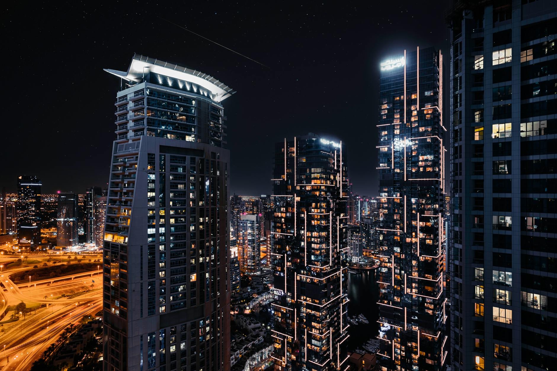 Illuminated high-rise towers crowd a city skyline at night