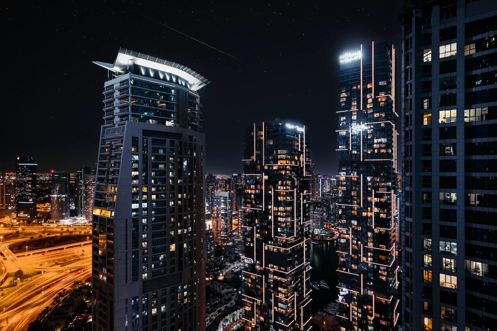 Illuminated high-rise towers crowd a city skyline at night