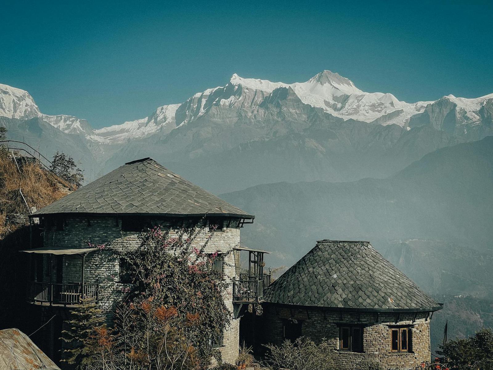 Traditional stone houses set against the breathtaking Annapurna Himalayas in Nepal