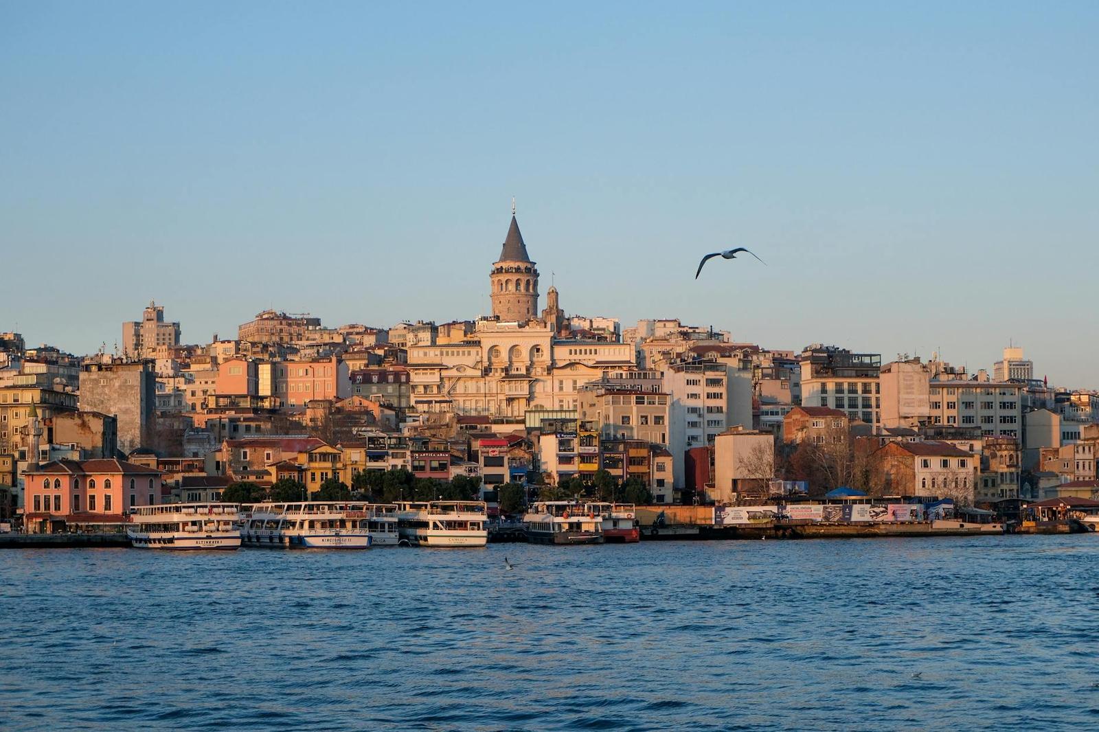 Historic hillside district with a stone tower seen across the water at sunset