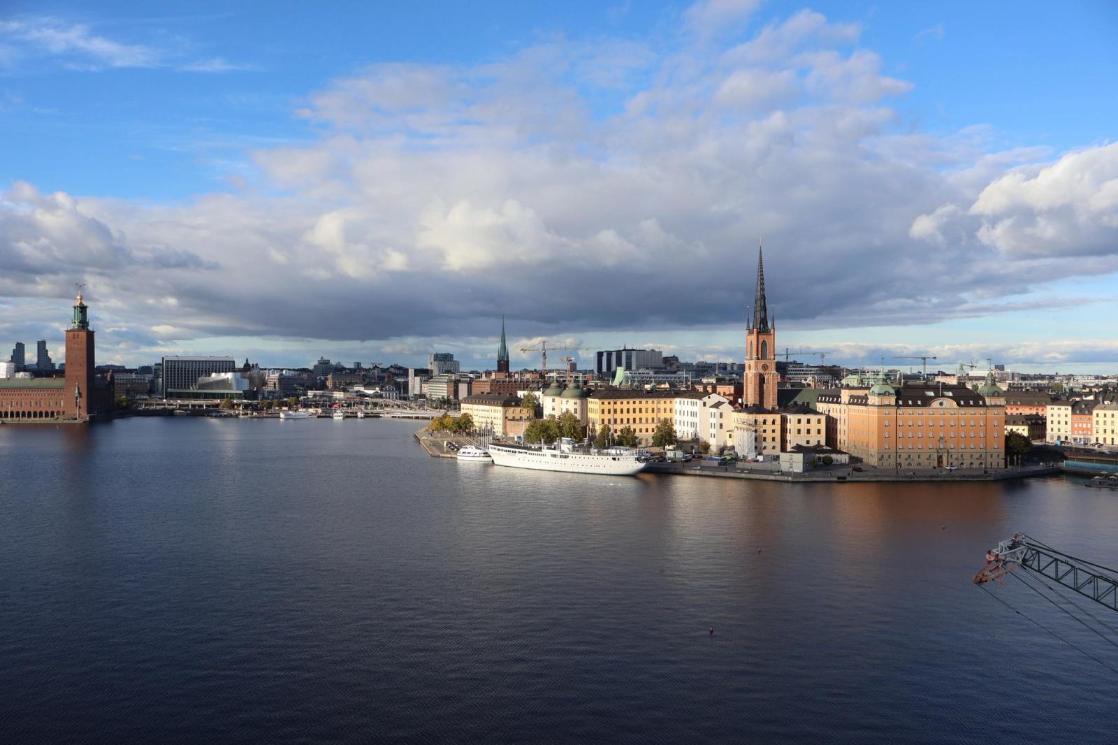 Aerial view of Stockholm's skyline with historic architecture by the waterfront under a blue sky