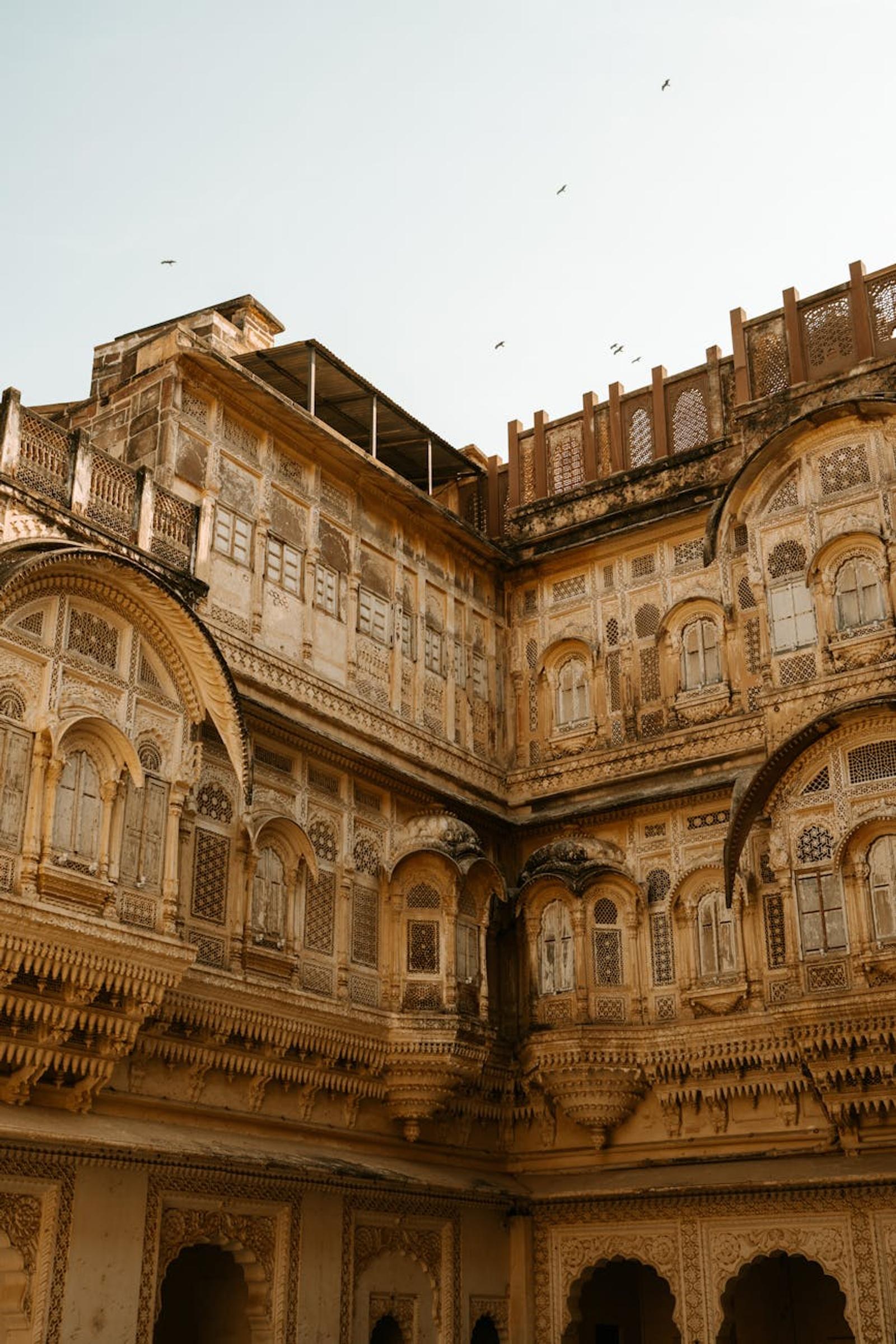 Ornately carved sandstone courtyard with tiered balconies and latticed windows