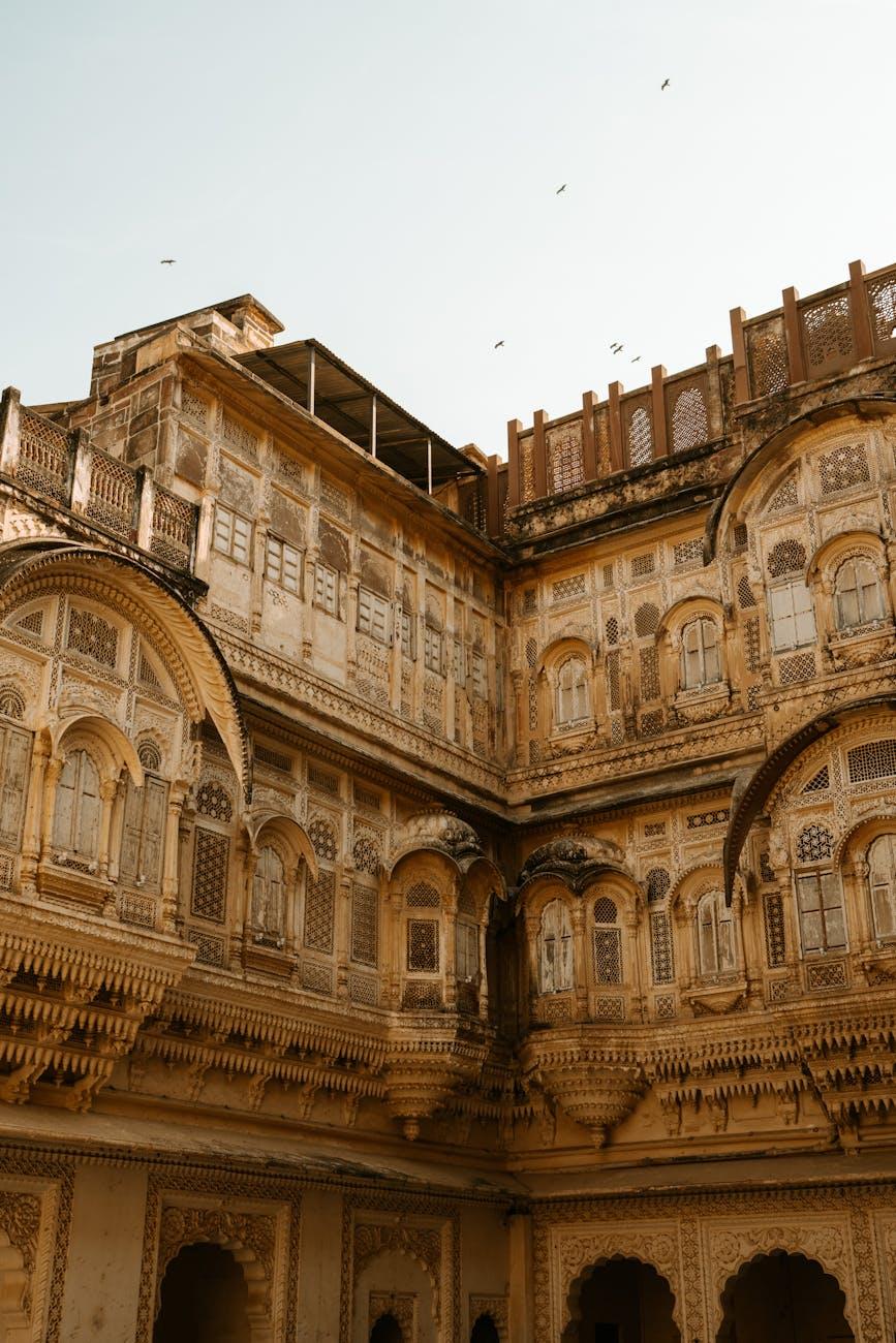 Ornately carved sandstone courtyard with tiered balconies and latticed windows