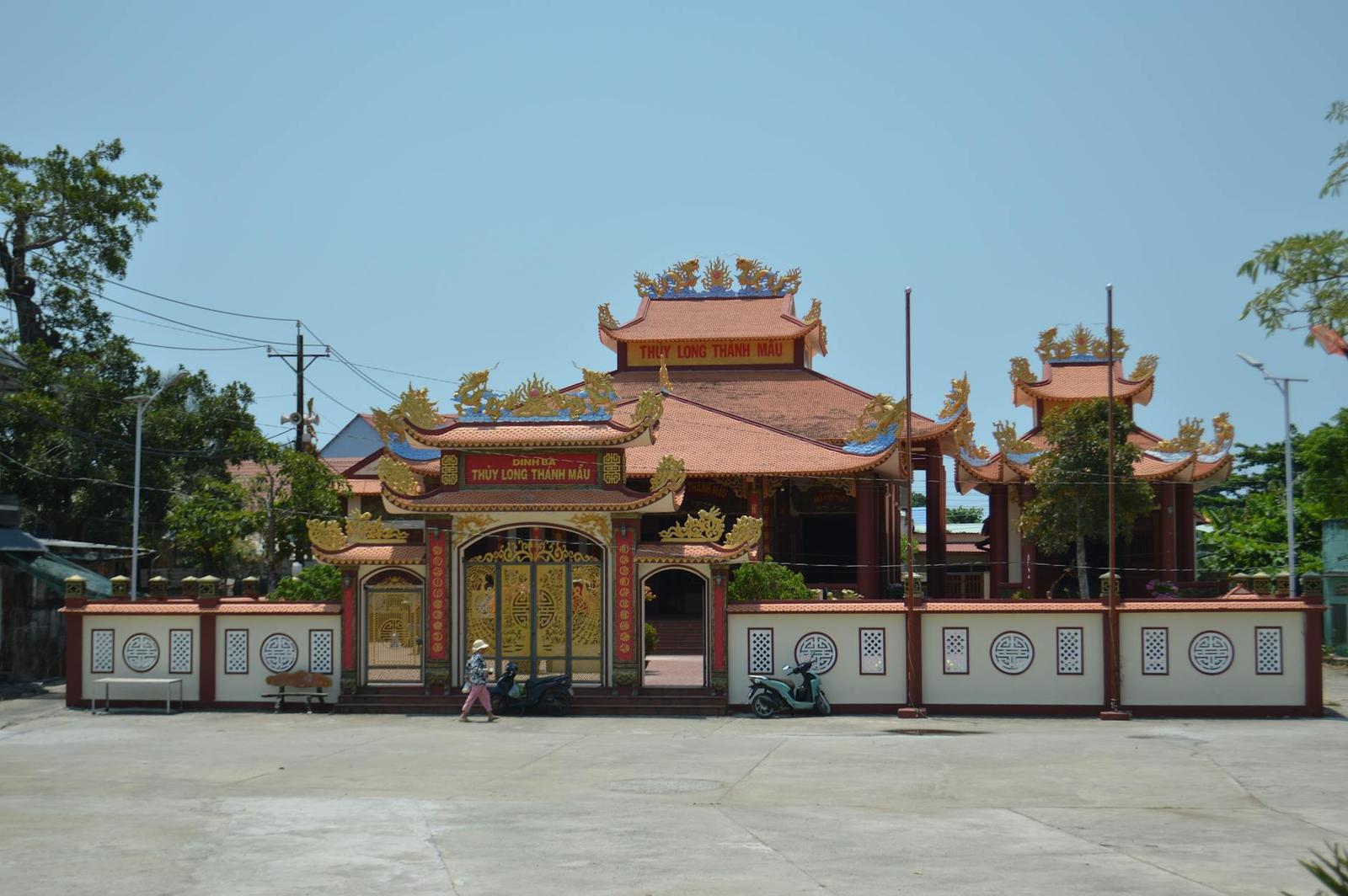 Ornate red and gold temple gate opening onto an empty forecourt