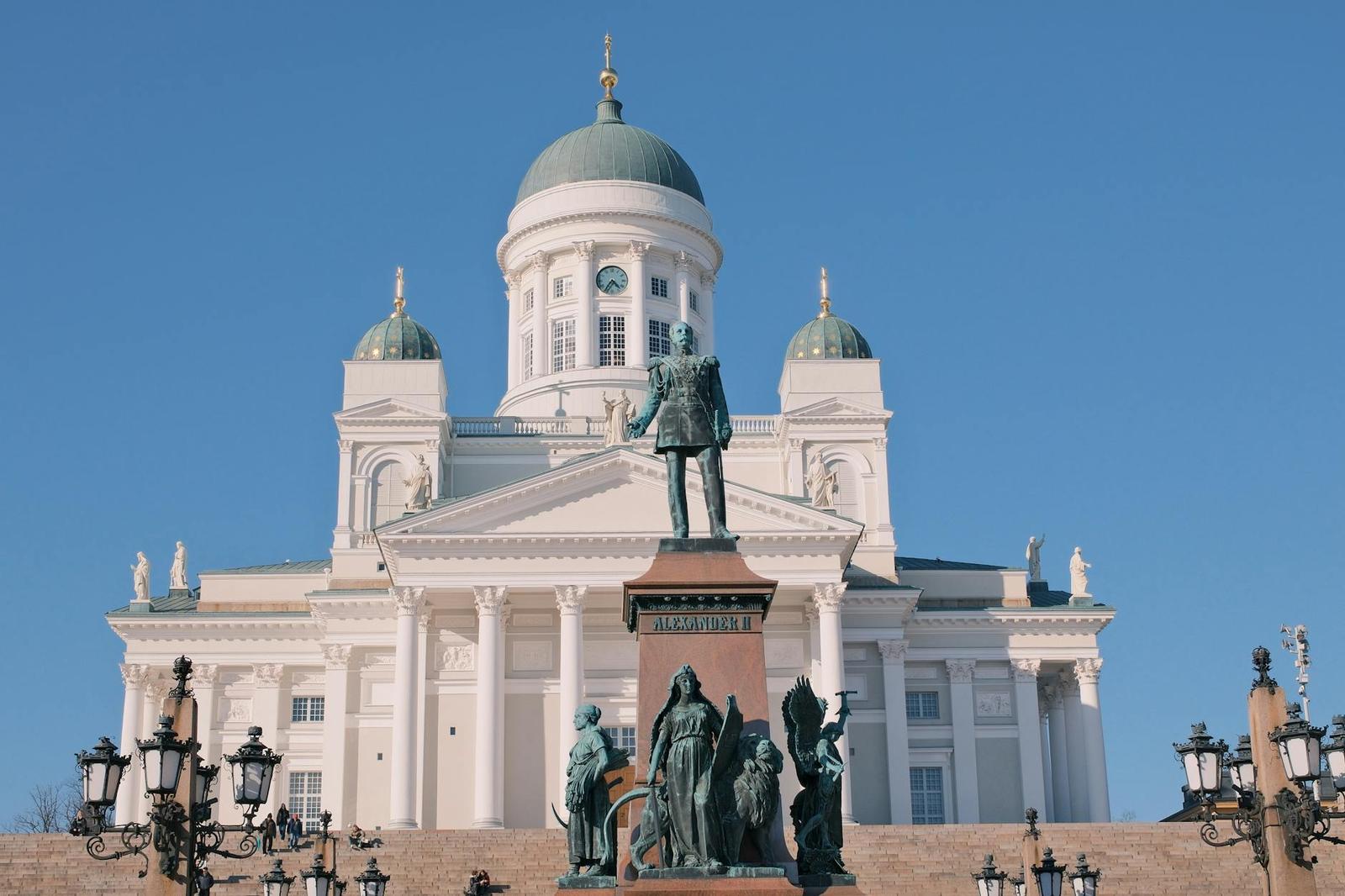 View of Helsinki Cathedral and iconic Alexander II statue under clear blue skies