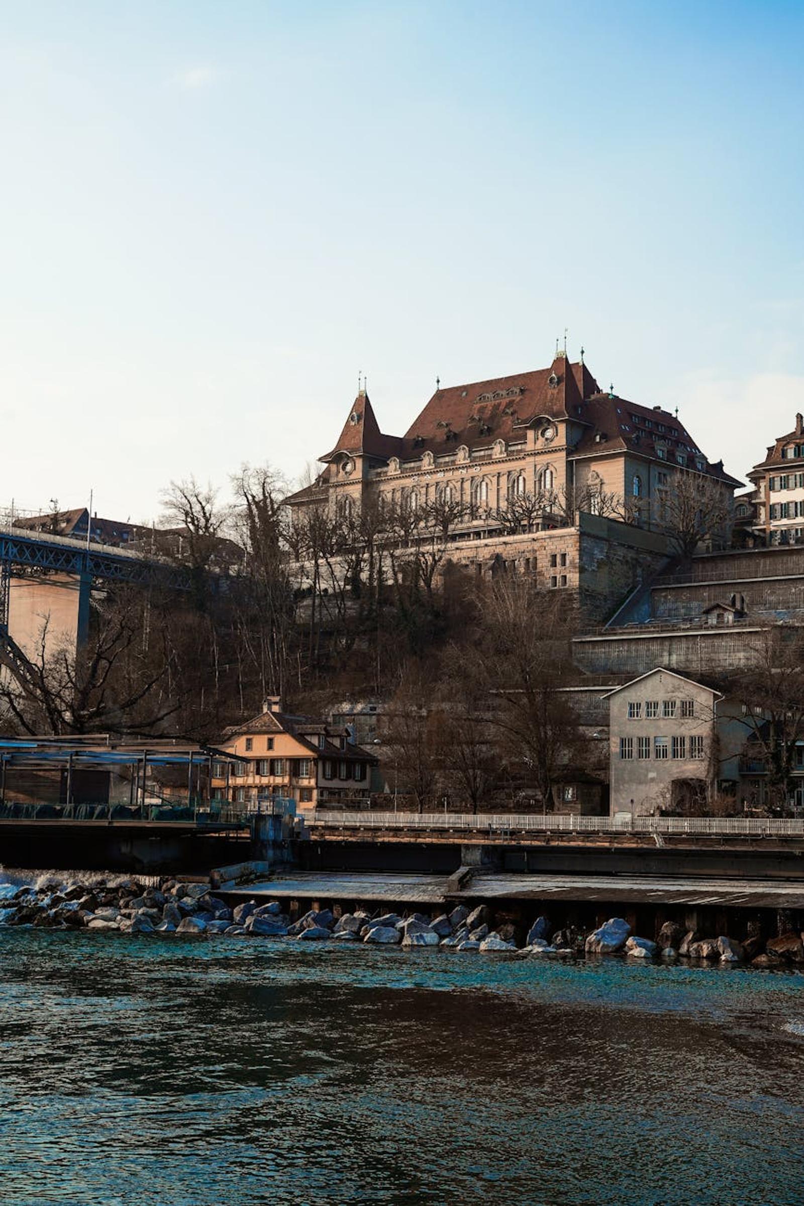 Scenic view of a historic building by the Aare River in Bern, Switzerland, under a clear sky