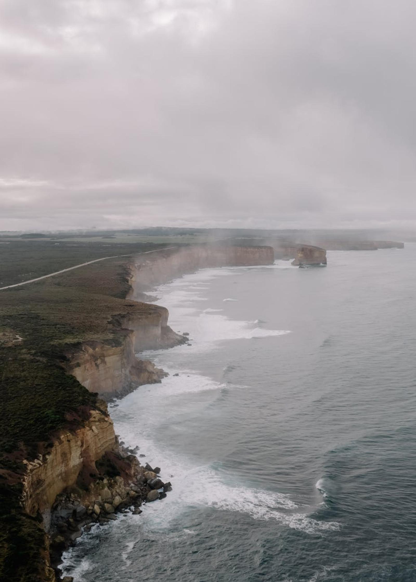 Aerial view of the scenic and rugged cliffs along the coast of Anglesea, VIC, Australia under overcast skies