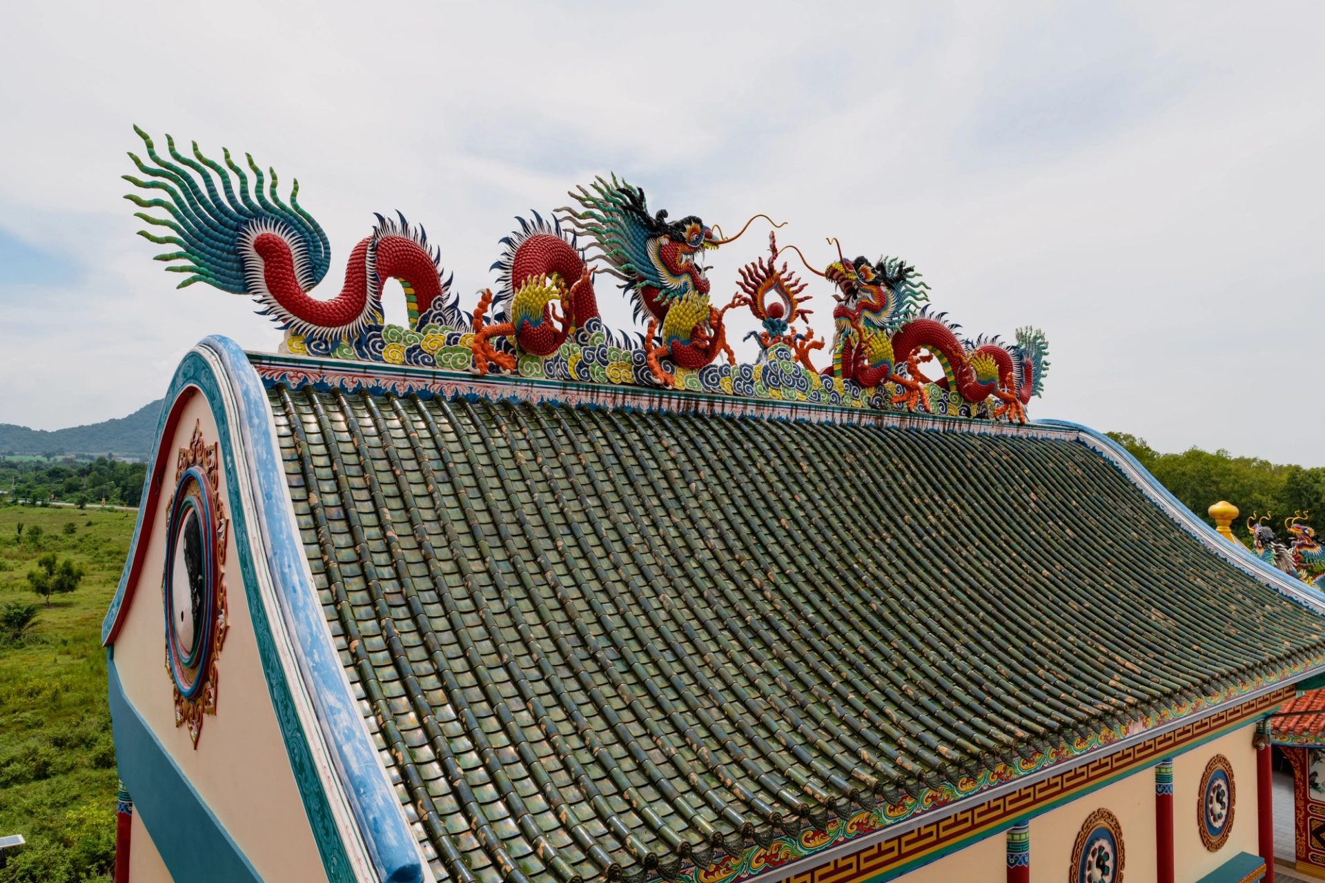 Colorful dragon sculptures on a temple roof in Pattaya, Thailand, showcasing traditional artistry