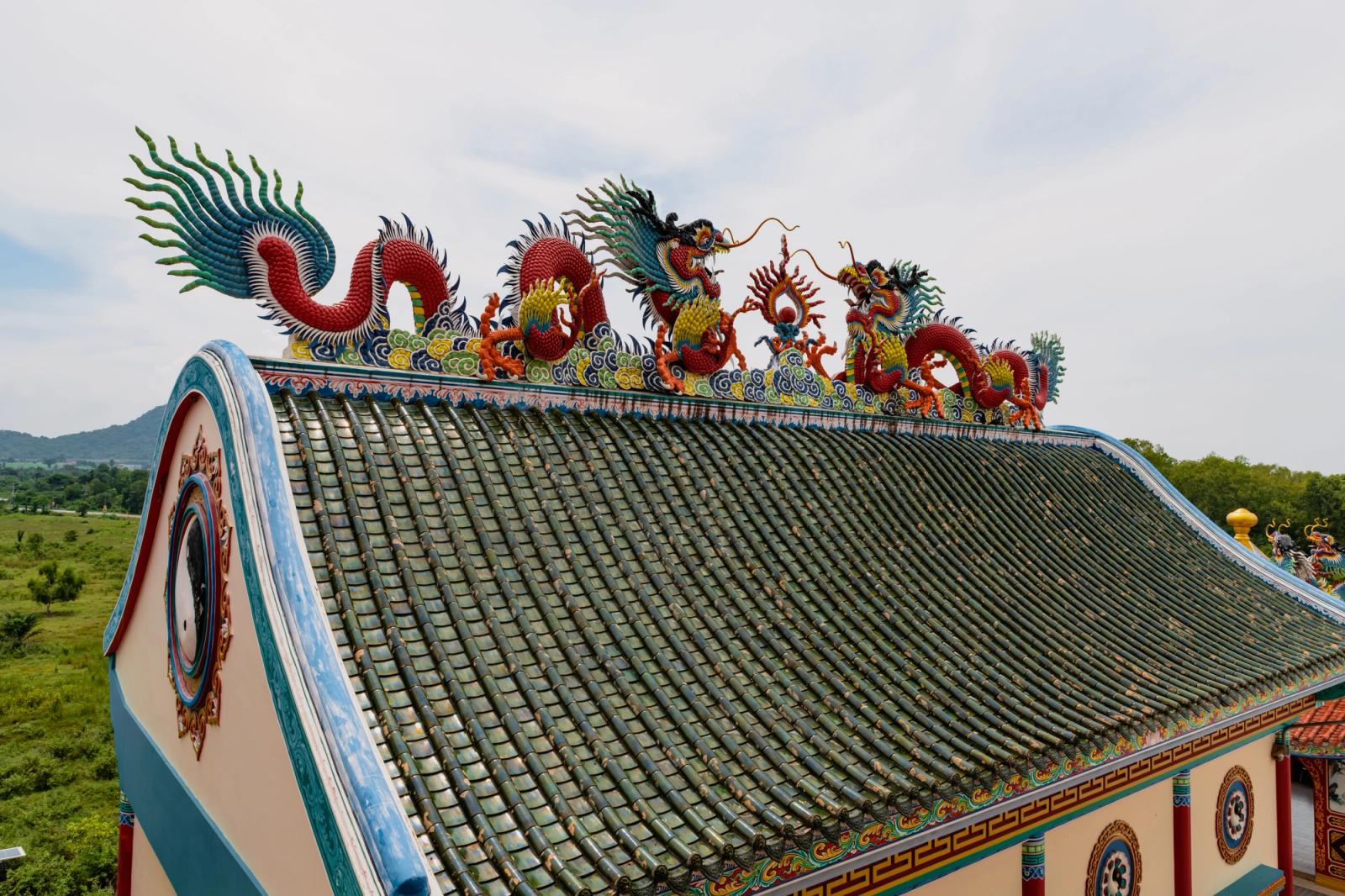 Colorful dragon sculptures on a temple roof in Pattaya, Thailand, showcasing traditional artistry