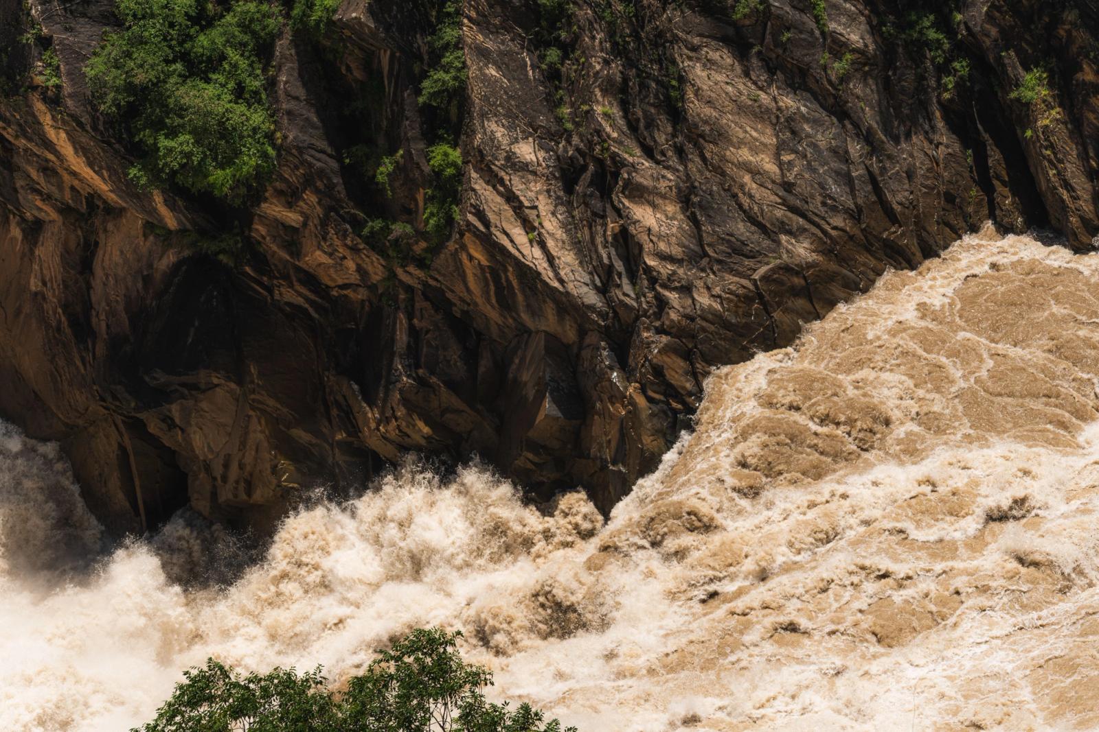 Dynamic river rapids cascade turbulently through a rocky gorge, showcasing nature's raw power