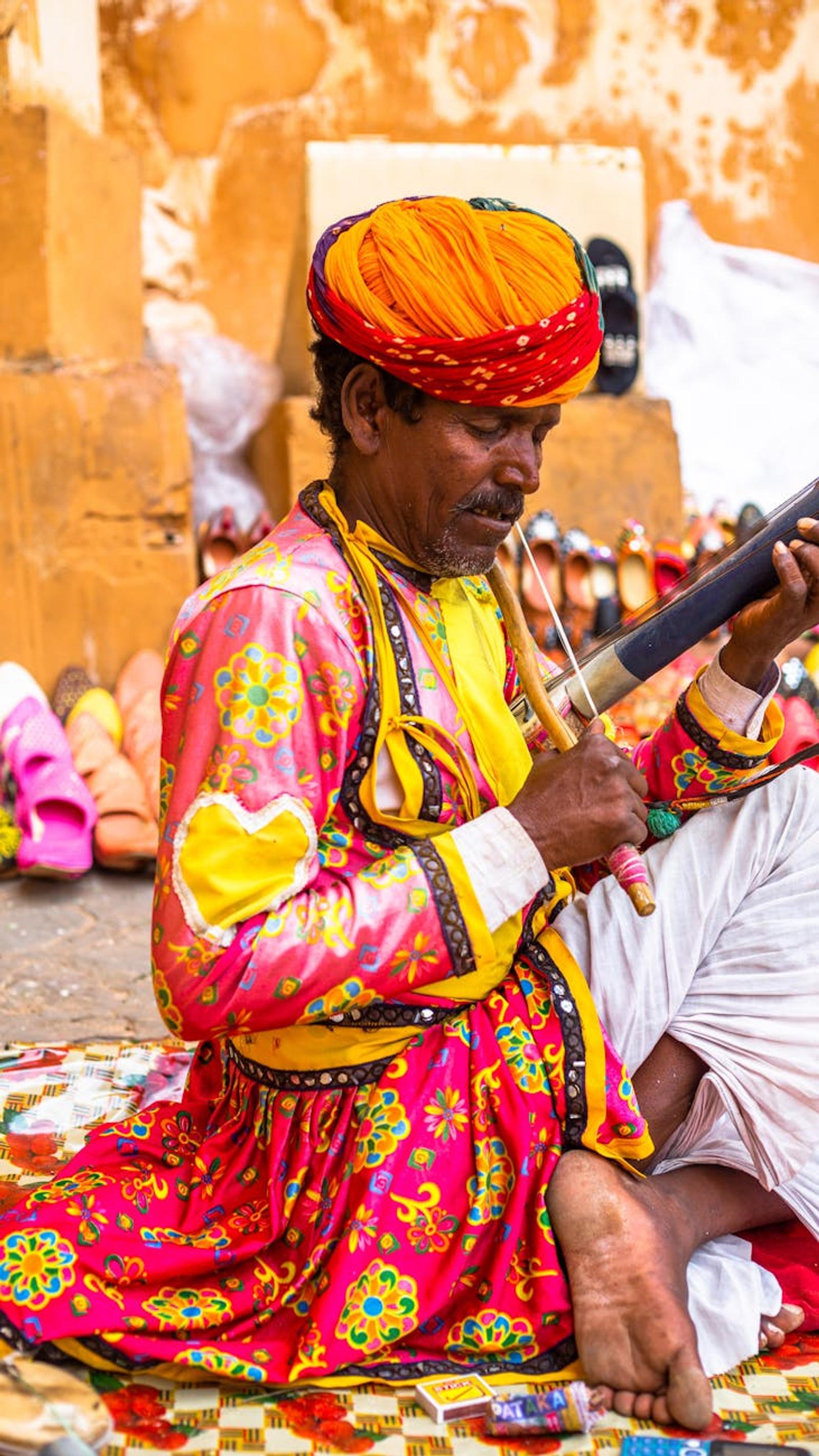 A Rajasthani artist plays traditional music in vibrant attire