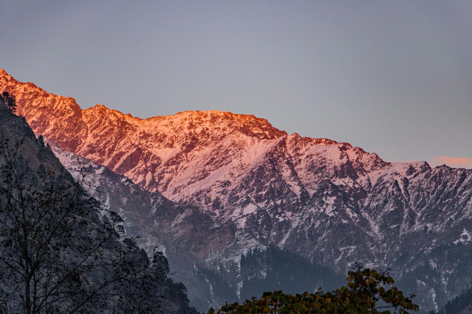 Snow dusted peaks glowing orange at first light