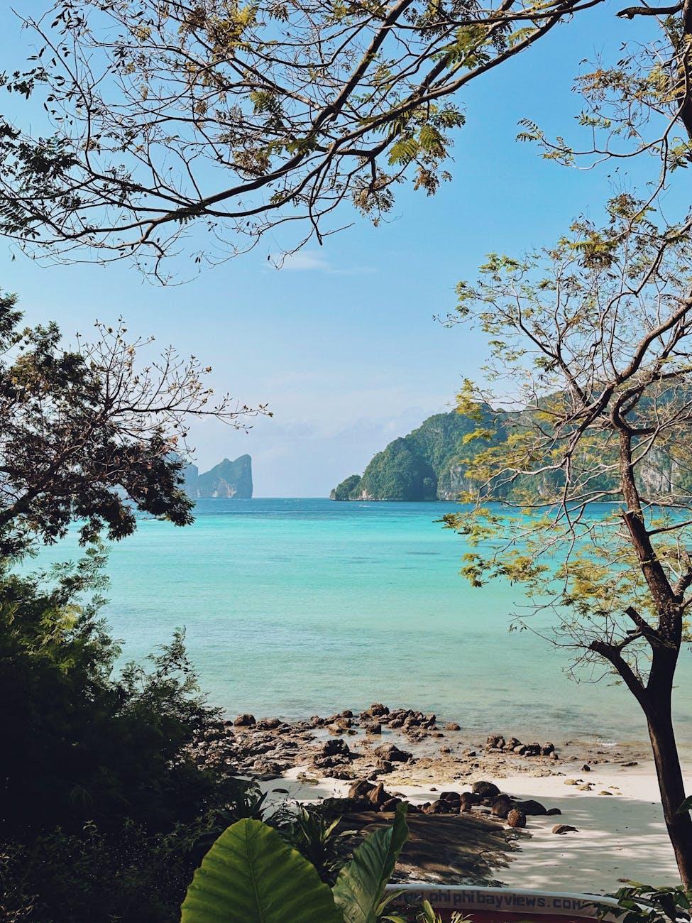 Serene tropical beach with crystal-clear turquoise waters surrounded by lush greenery