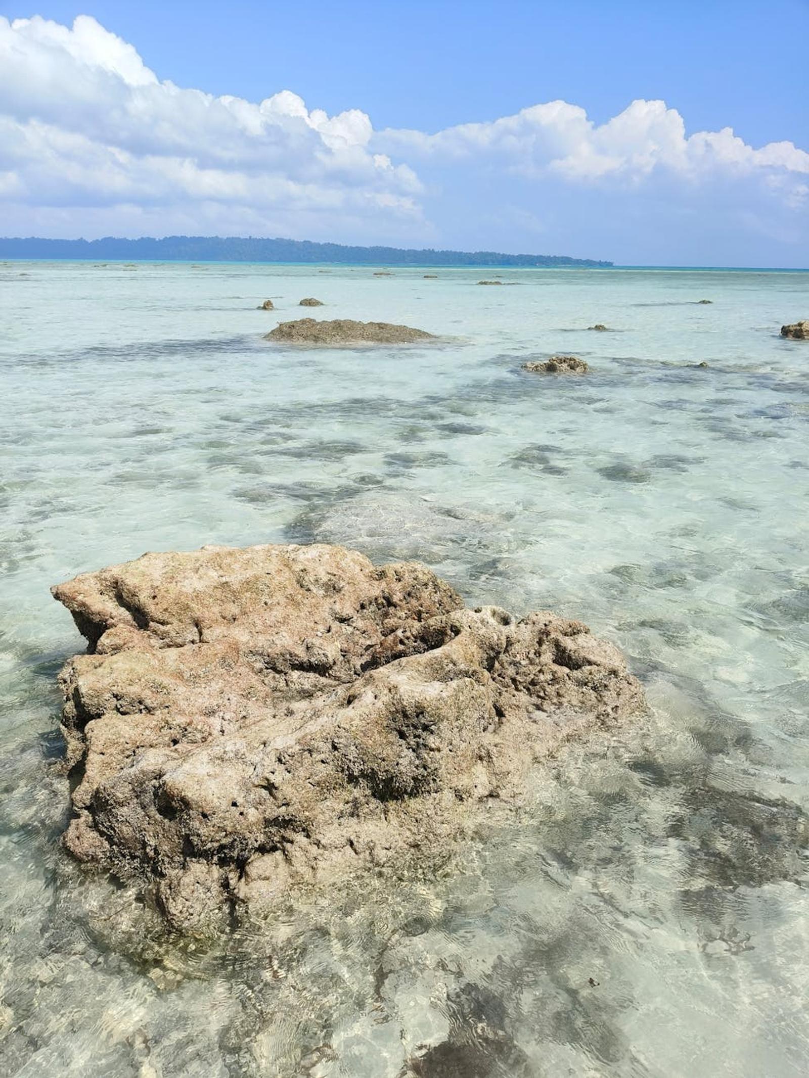 Pristine rocks in clear shallow sea under a bright blue sky