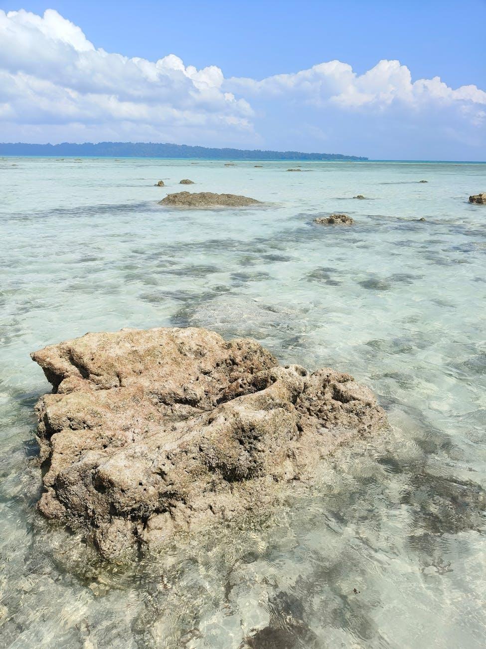 Pristine rocks in clear shallow sea under a bright blue sky