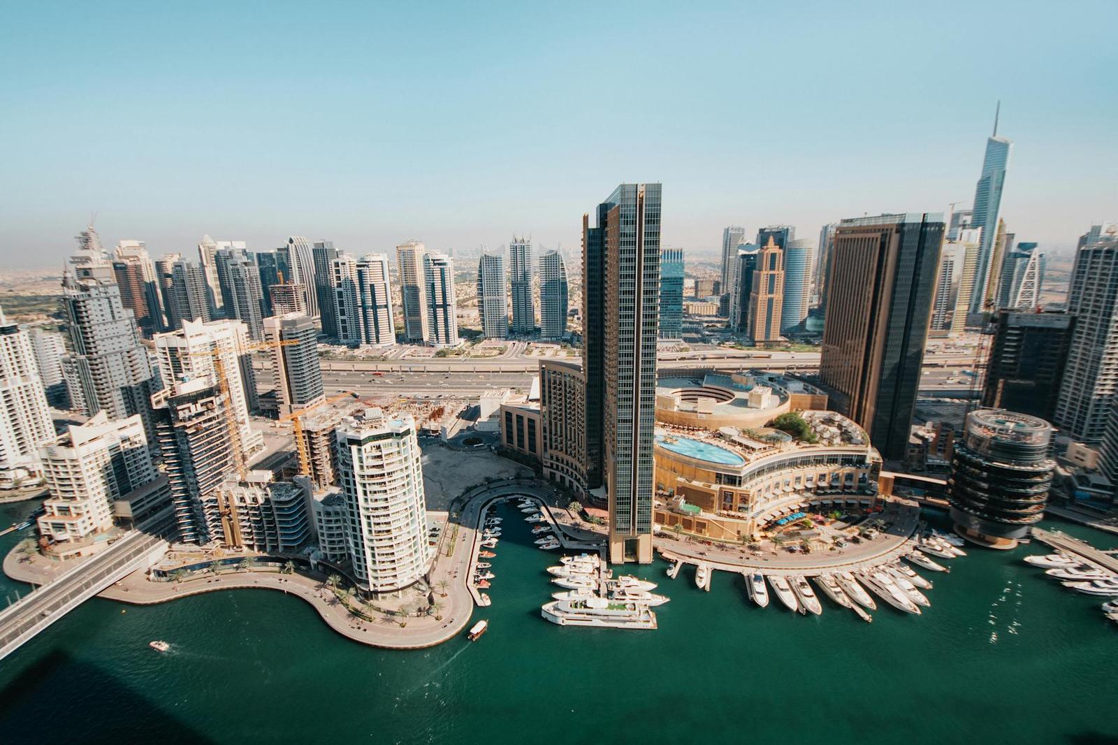 A marina lined with high-rise towers, boats and a waterfront promenade