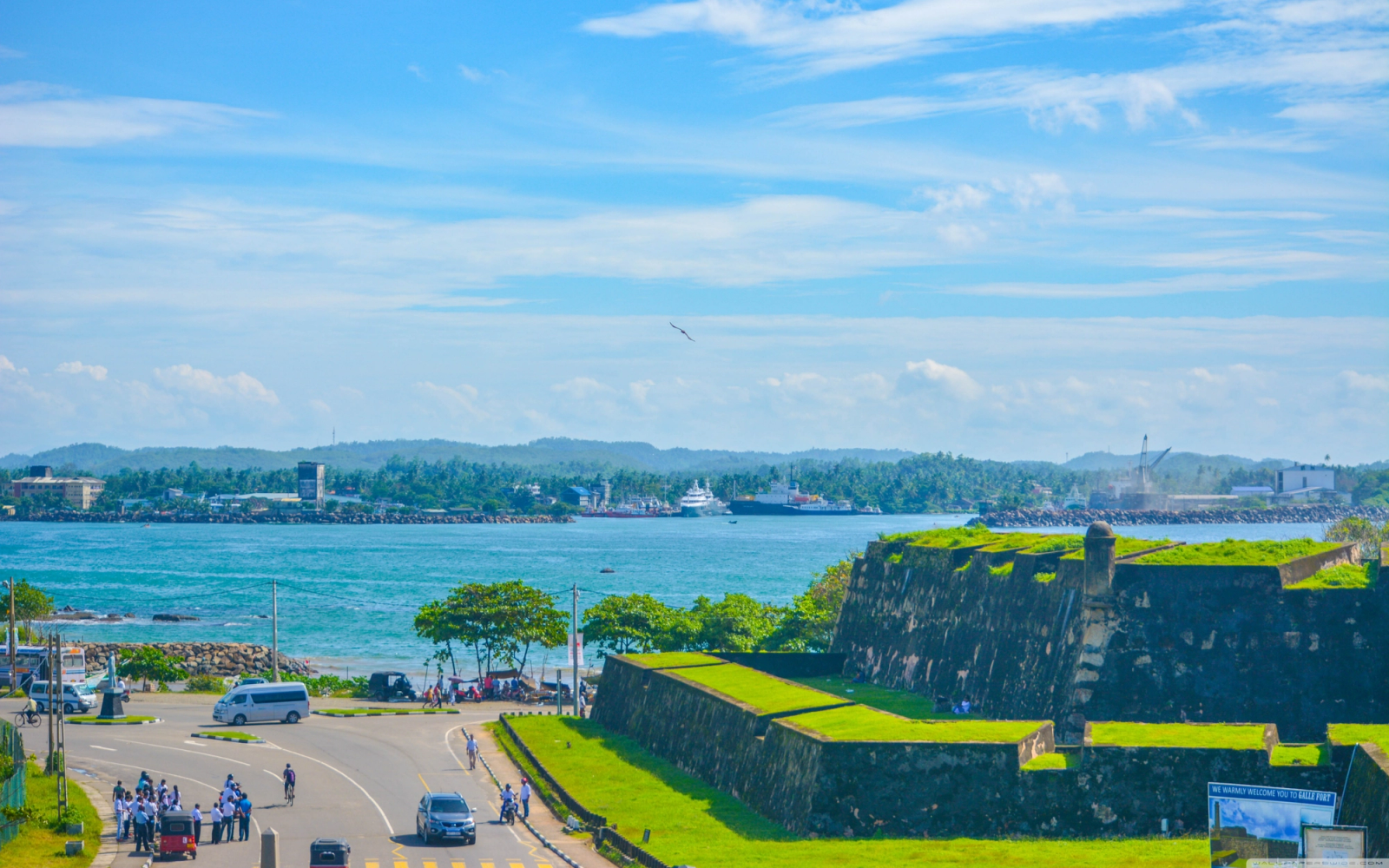 Grass-topped stone fort ramparts overlooking a harbour and coastline